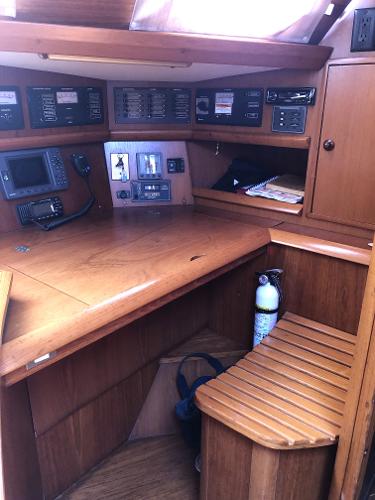 Navigation station of 2001 Jeanneau 45.2 sailboat with wooden desk and control panels.