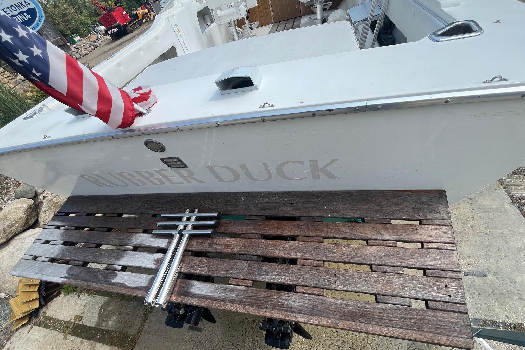 1975 Bertram 26 Moppie boat with American flag and wooden deck, named "Rubber Duck."