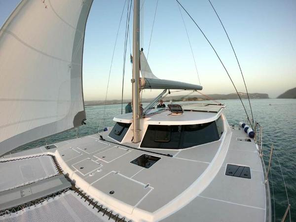 Sailing catamaran Vision 444, 2025 model, cruising on calm waters at sunset.