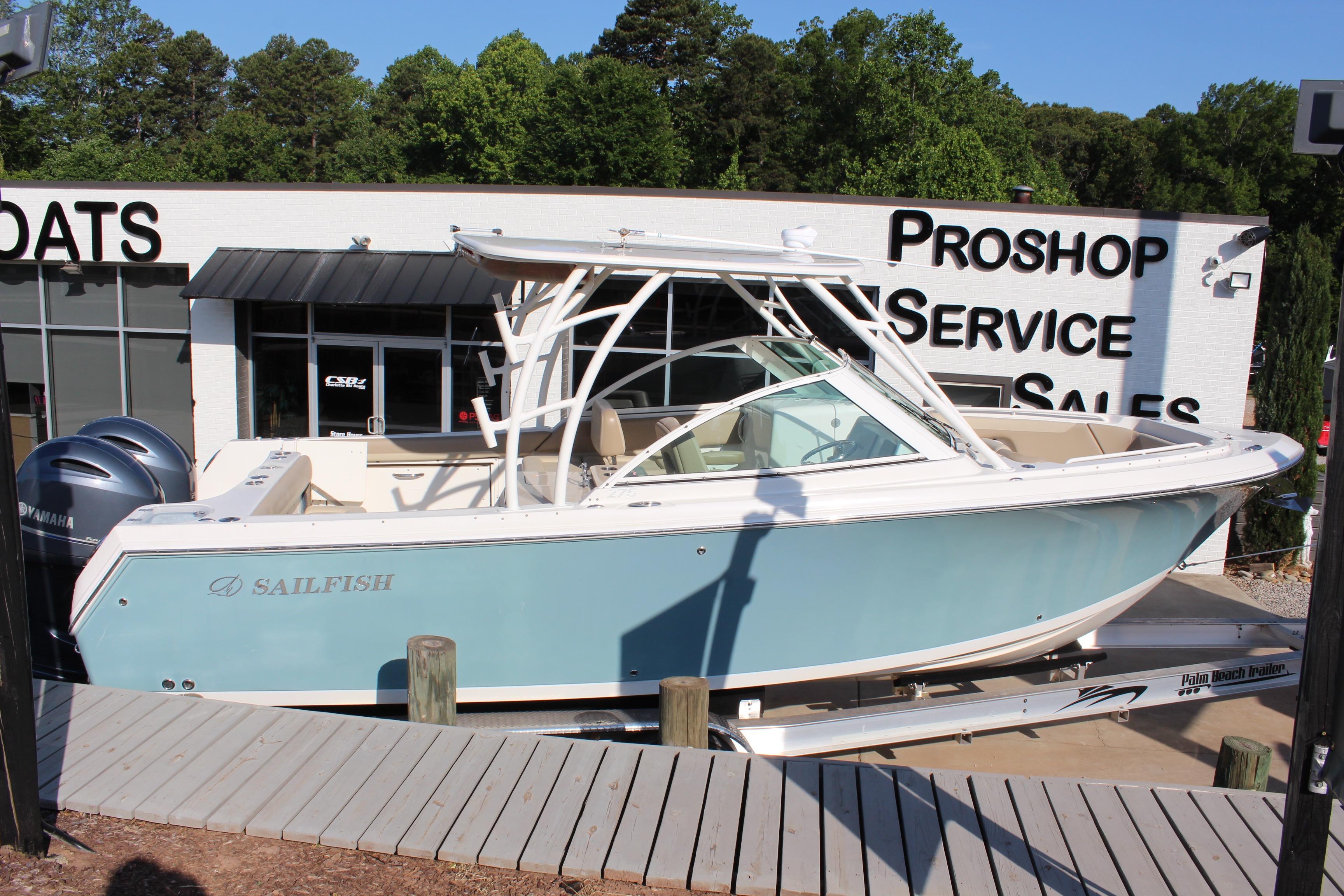 2017 Sailfish 275 DC boat displayed at a dealership with service and sales signage.