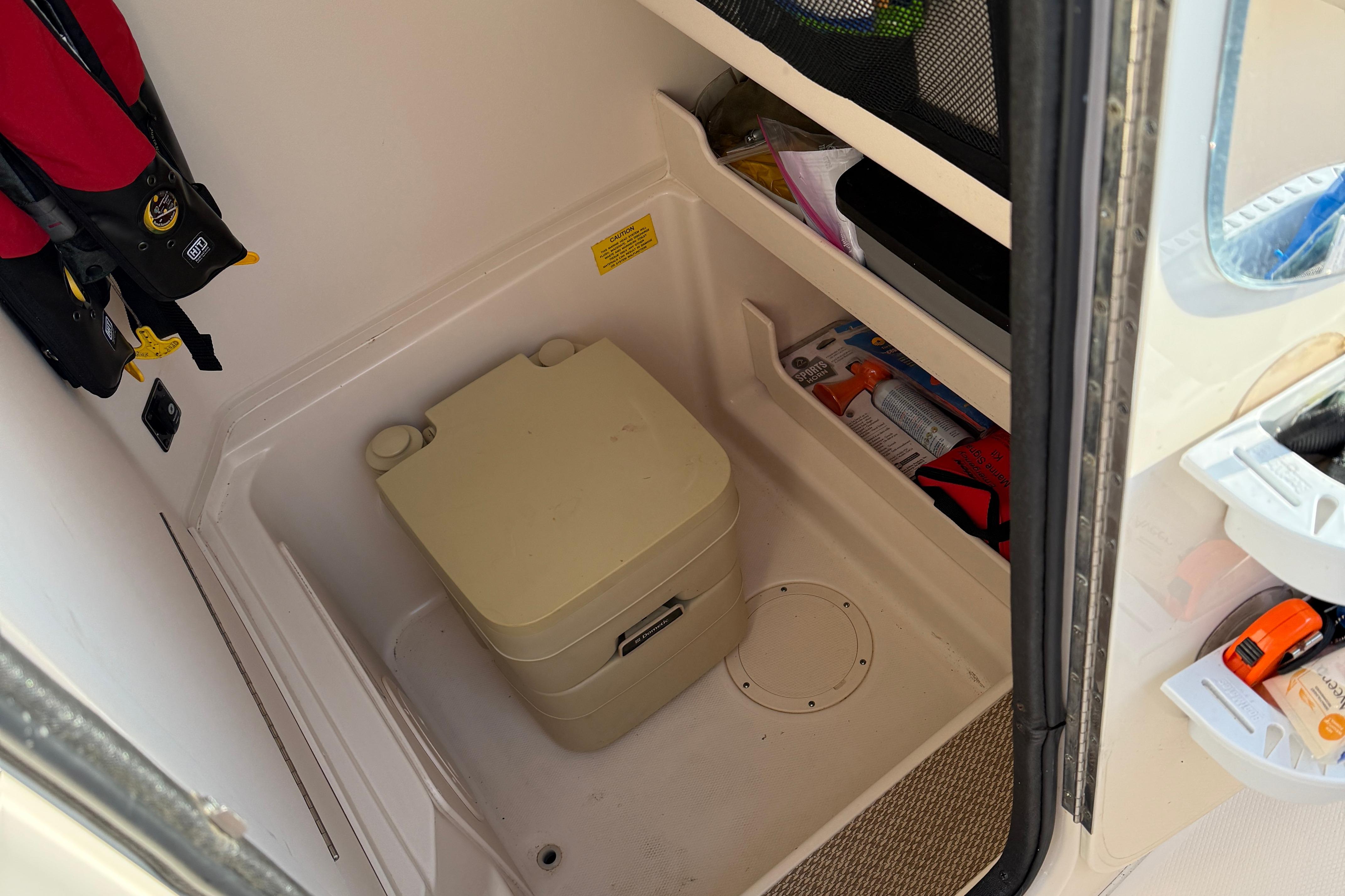 Interior of 2017 Grady White 257 Fisherman boat with storage and portable toilet.