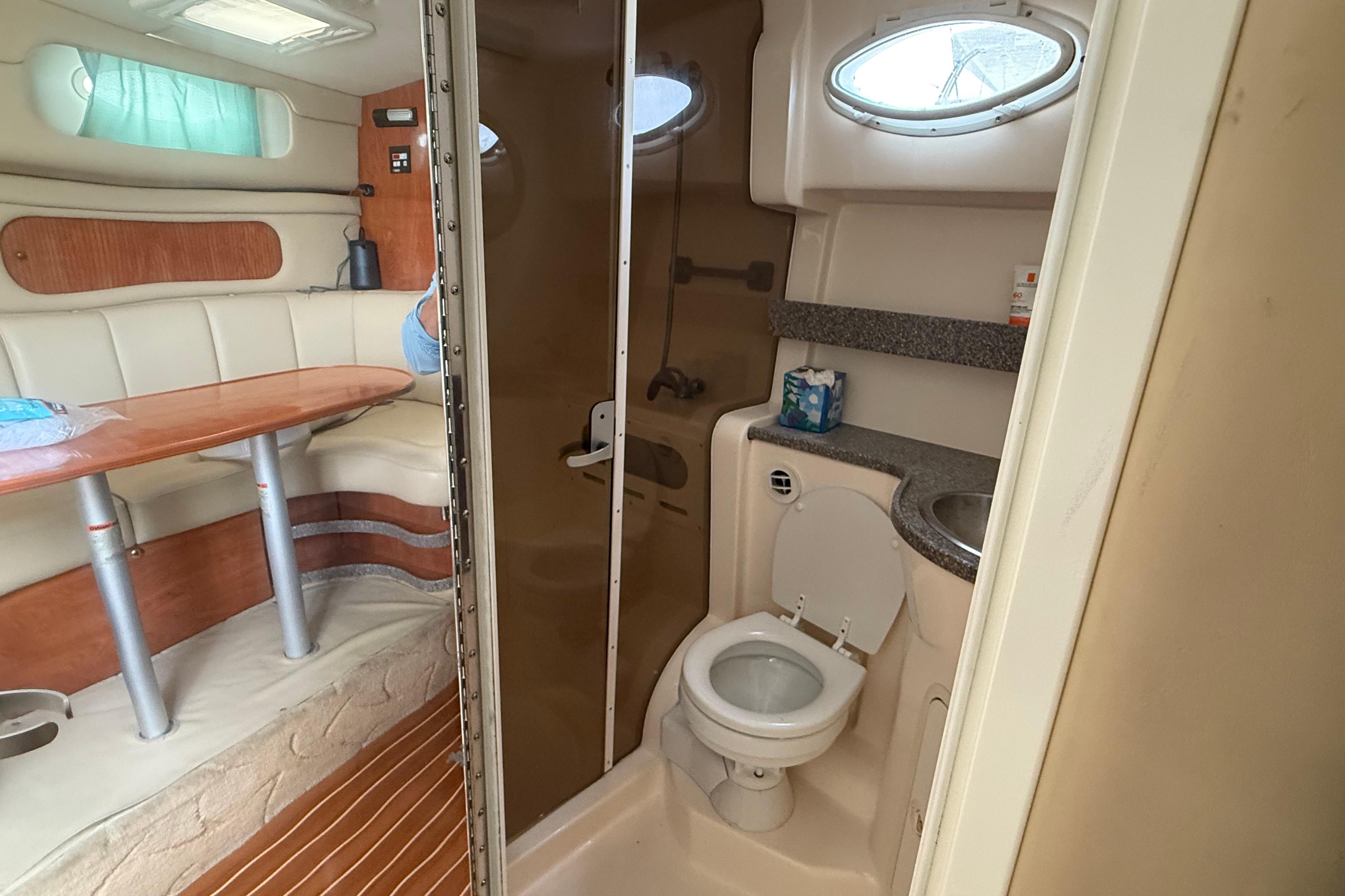 2004 Rinker 342 boat interior with dining area and compact bathroom.