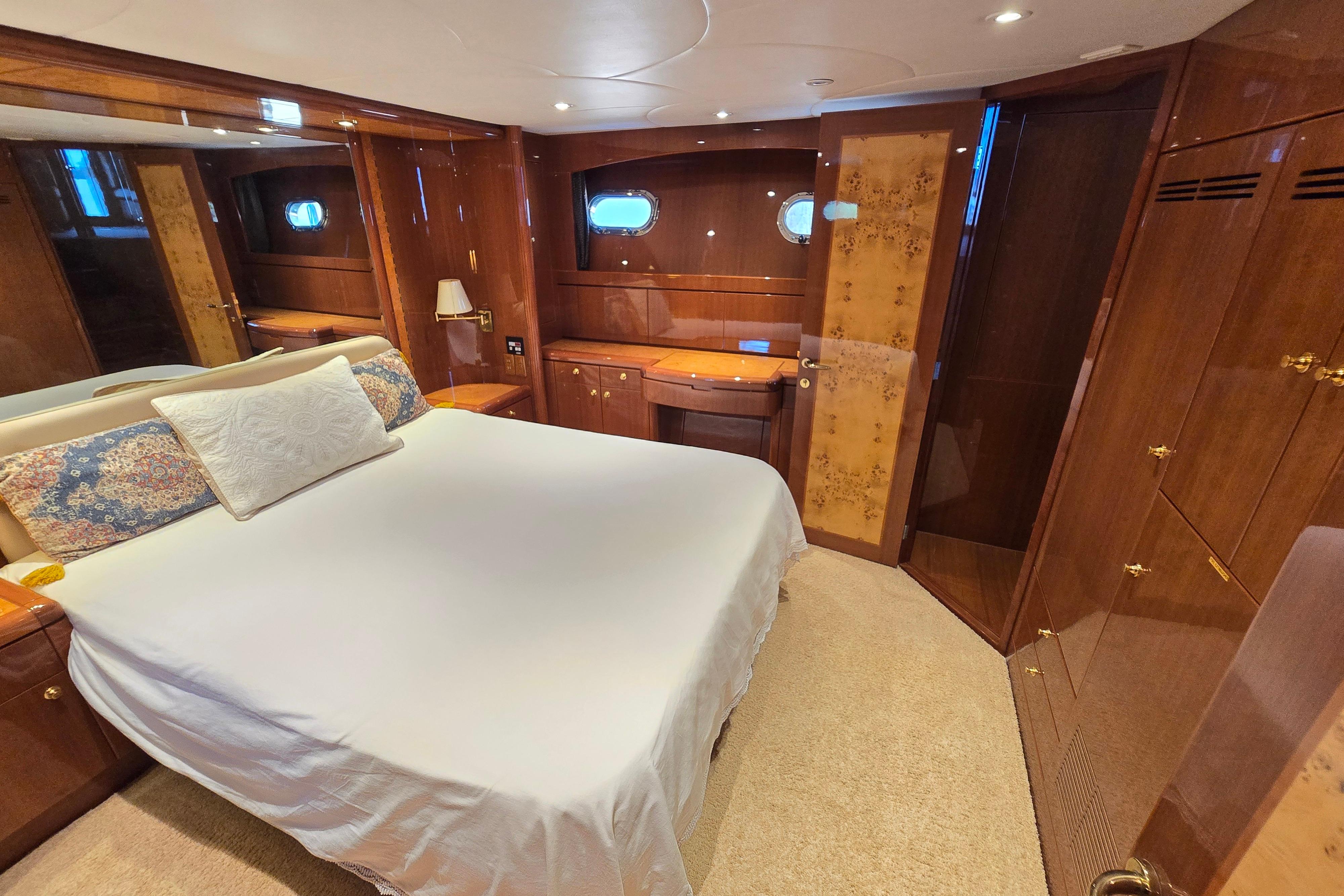 Luxurious bedroom interior of 2004 Grand Harbour 58 yacht with elegant wood finishes.