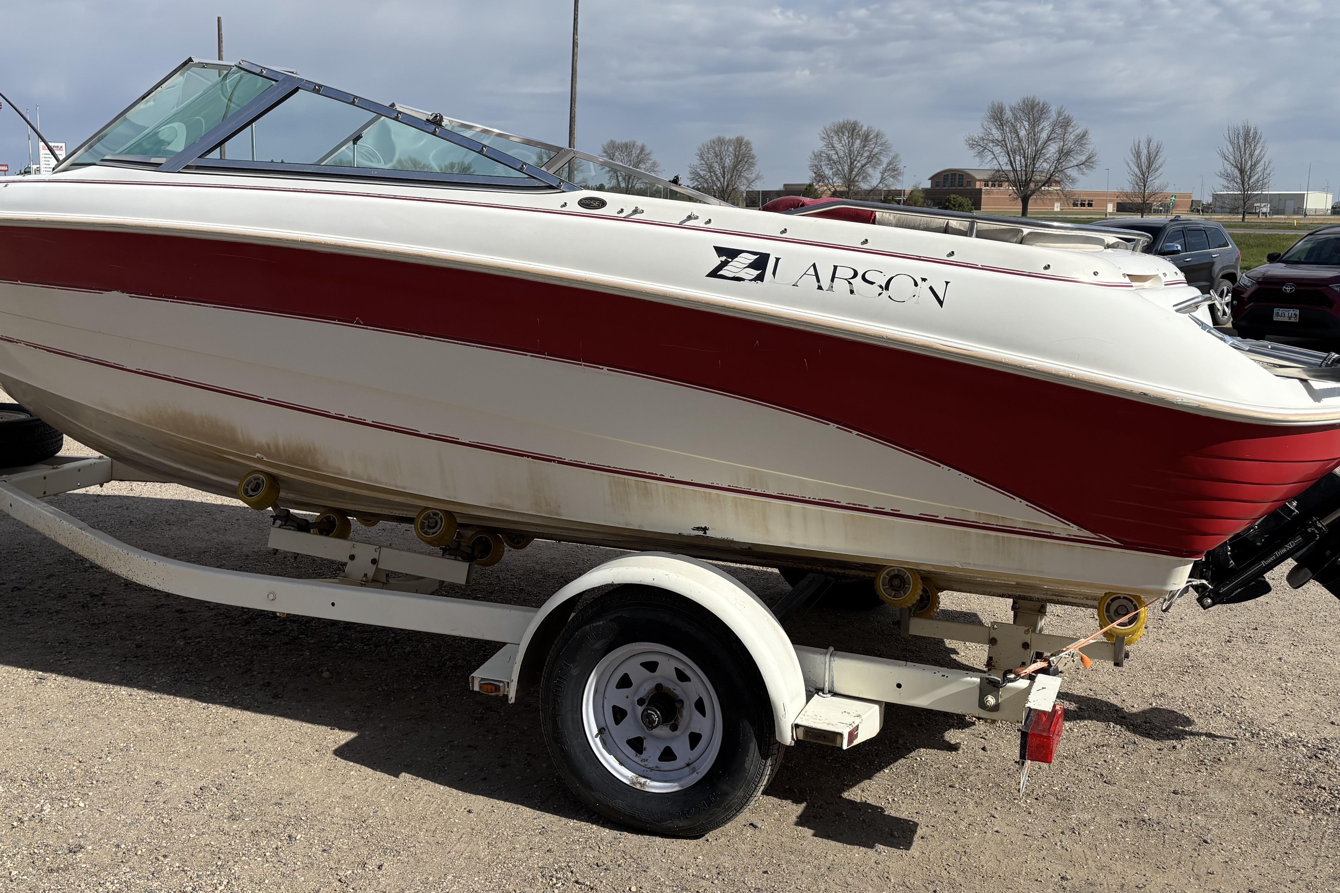 1993 Larson SEi 200 Cuddy I/O boat on trailer, red and white design.