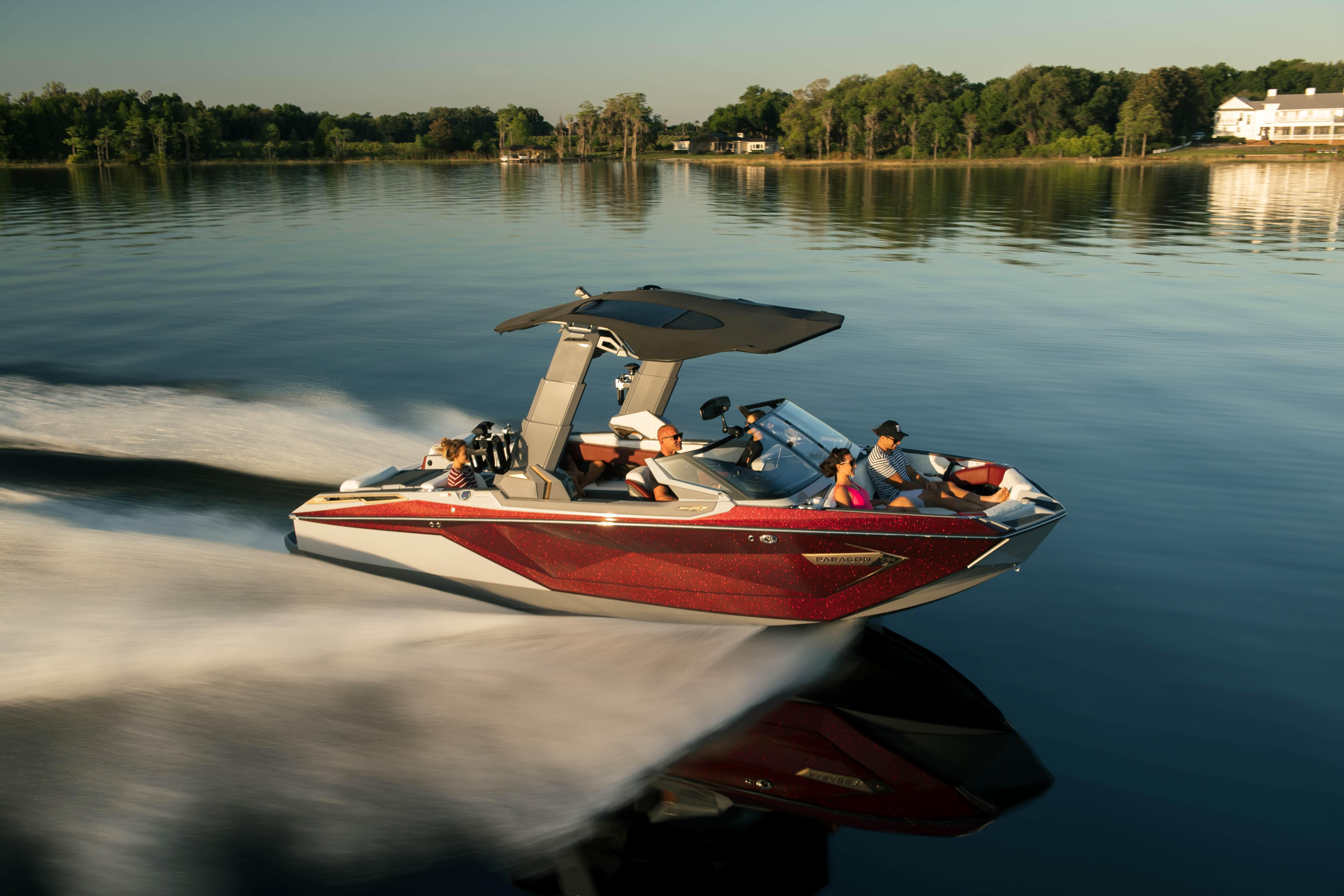 2026 Nautique G23 PARAGON boat cruising on a serene lake with passengers enjoying the ride.