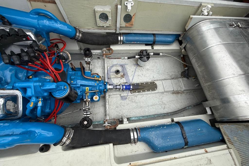 Engine compartment of a 1972 Riva Rudy boat, featuring blue engine components and metal fuel tank.