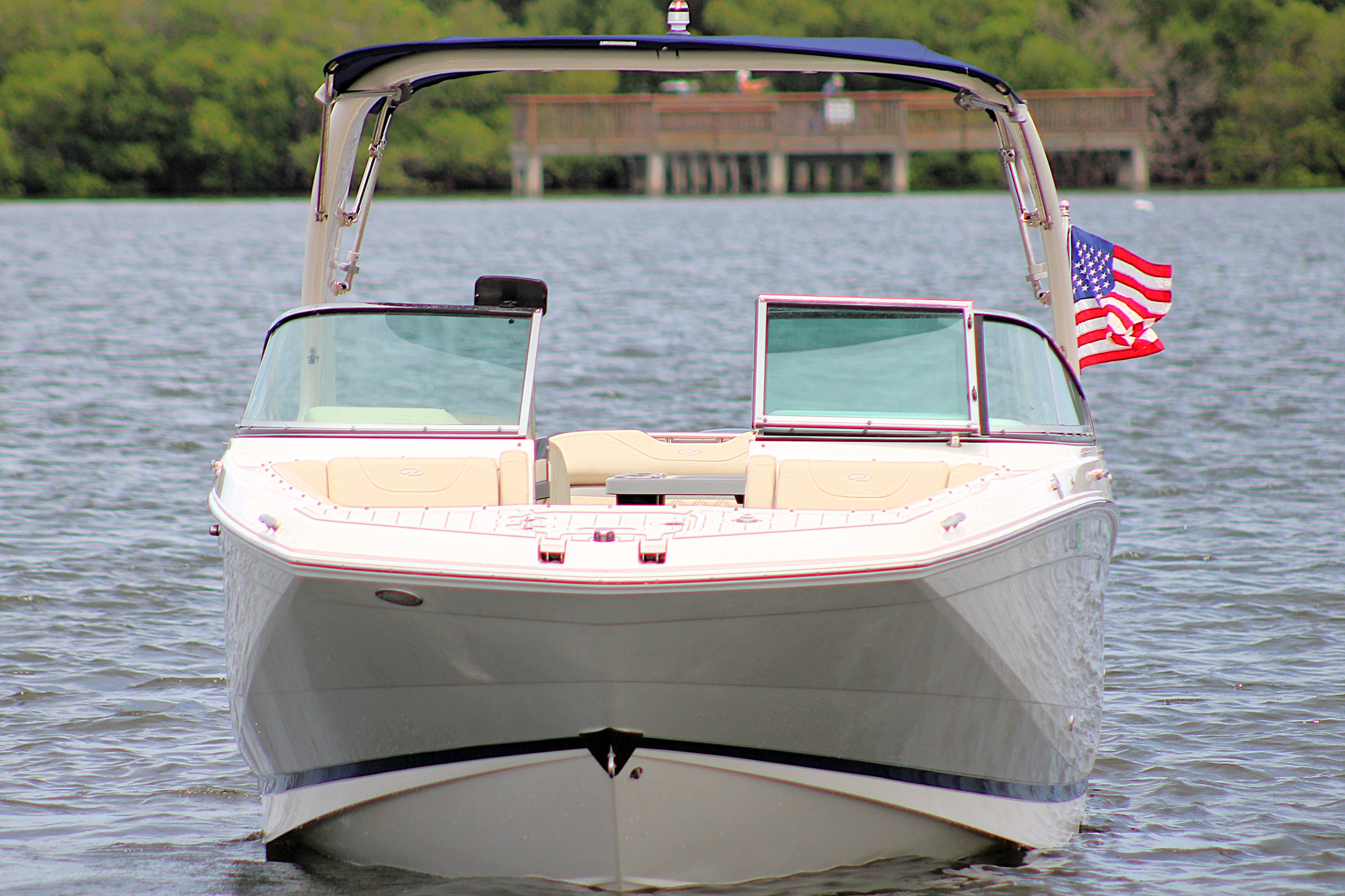 2021 Regal 26 OBX boat on water with American flag, front view.