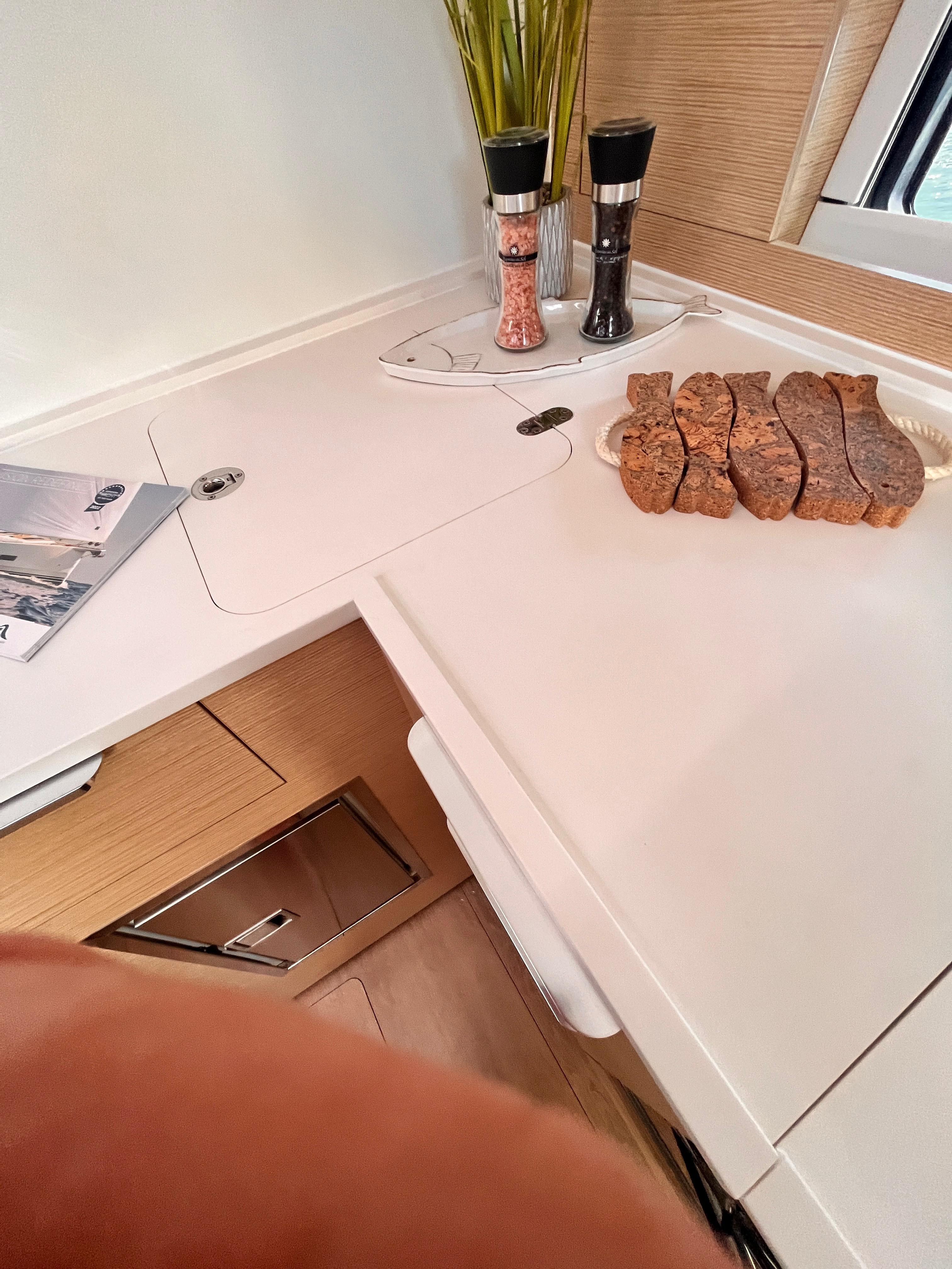 Modern kitchen area in 2023 Hanse 460 yacht with sliced bread and condiments.