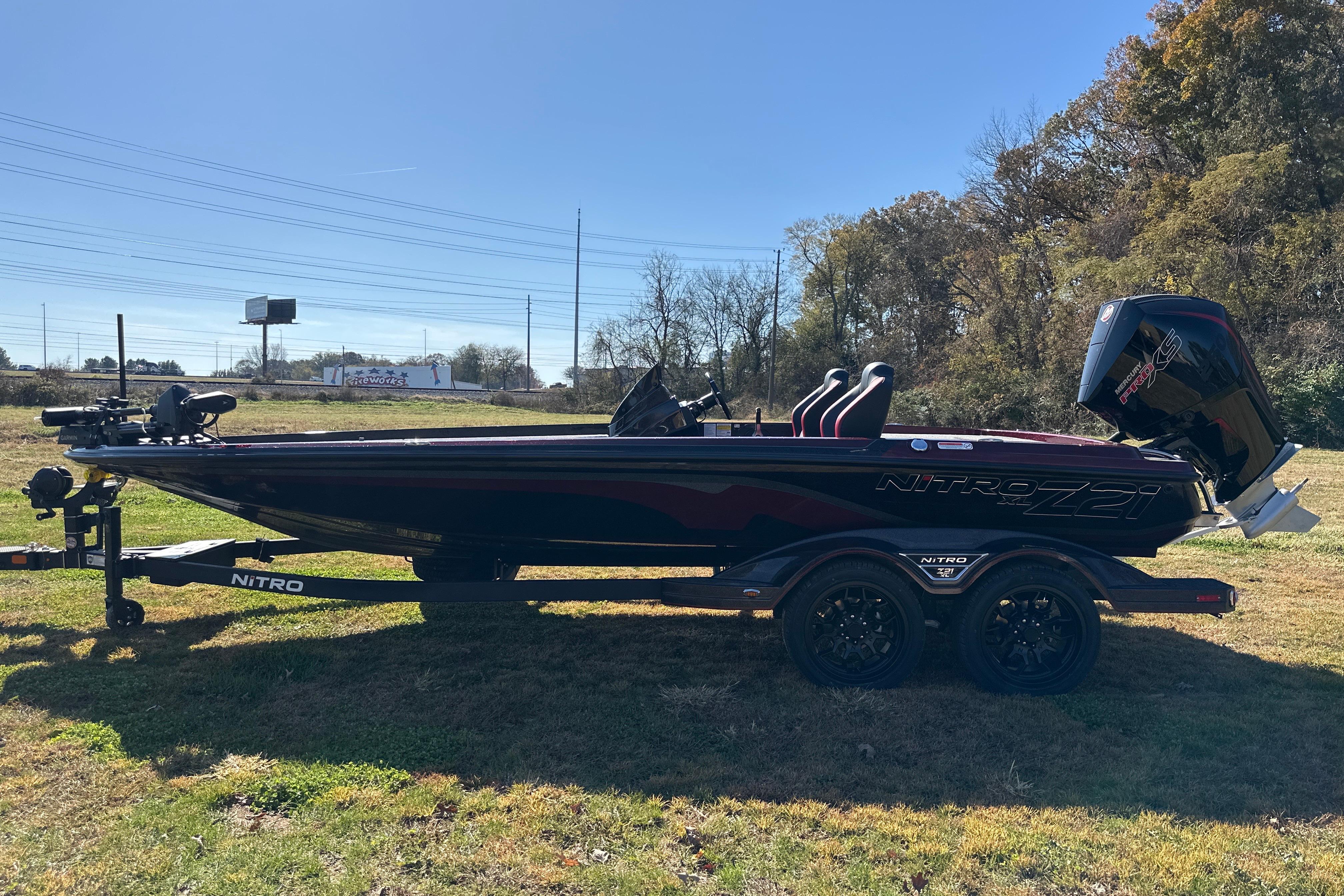 2026 Nitro Z21 XL Pro bass boat on trailer, parked on grass.