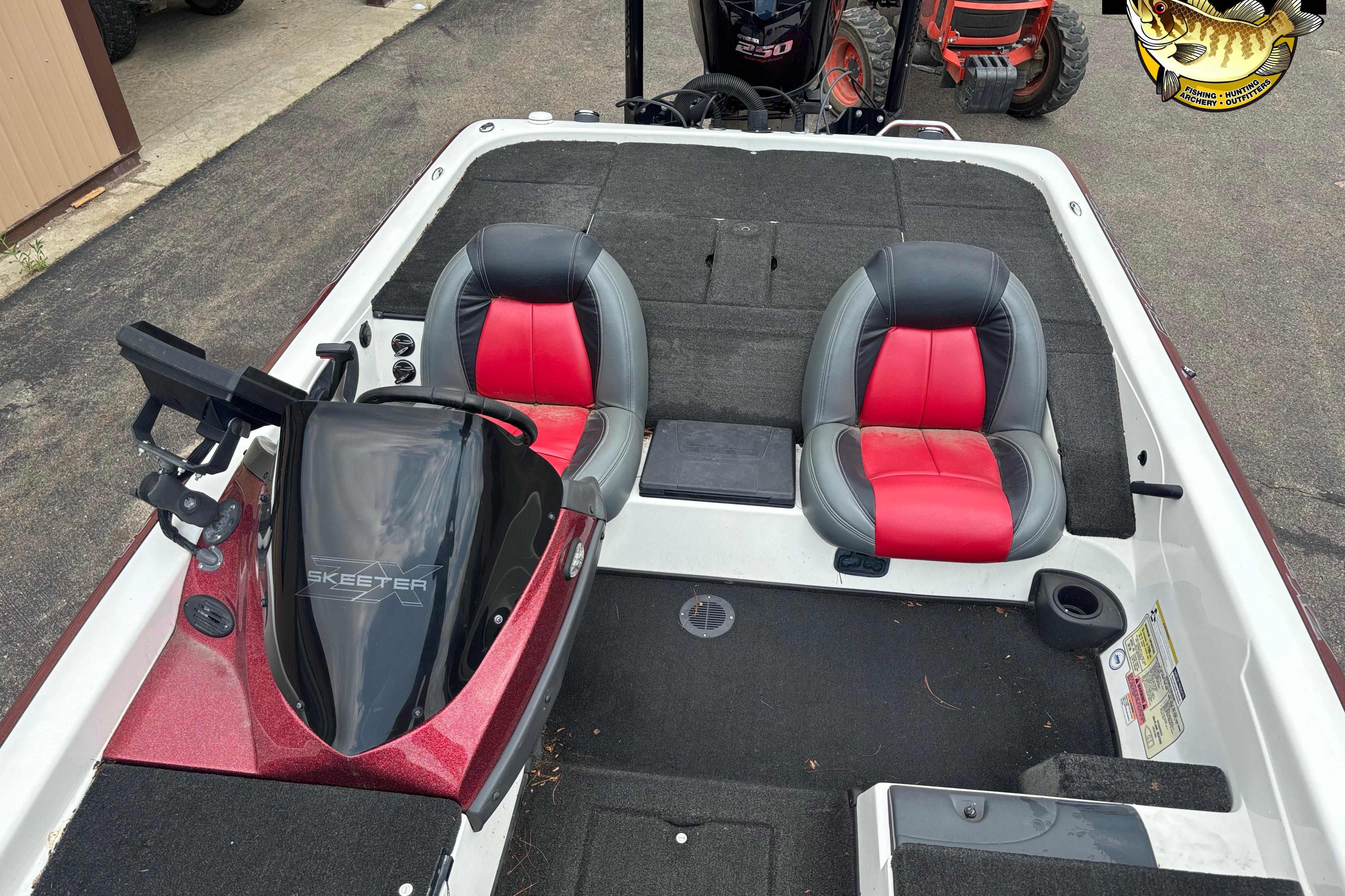 2013 Skeeter ZX20 boat interior with red and black seats, steering console, and carpeted deck.