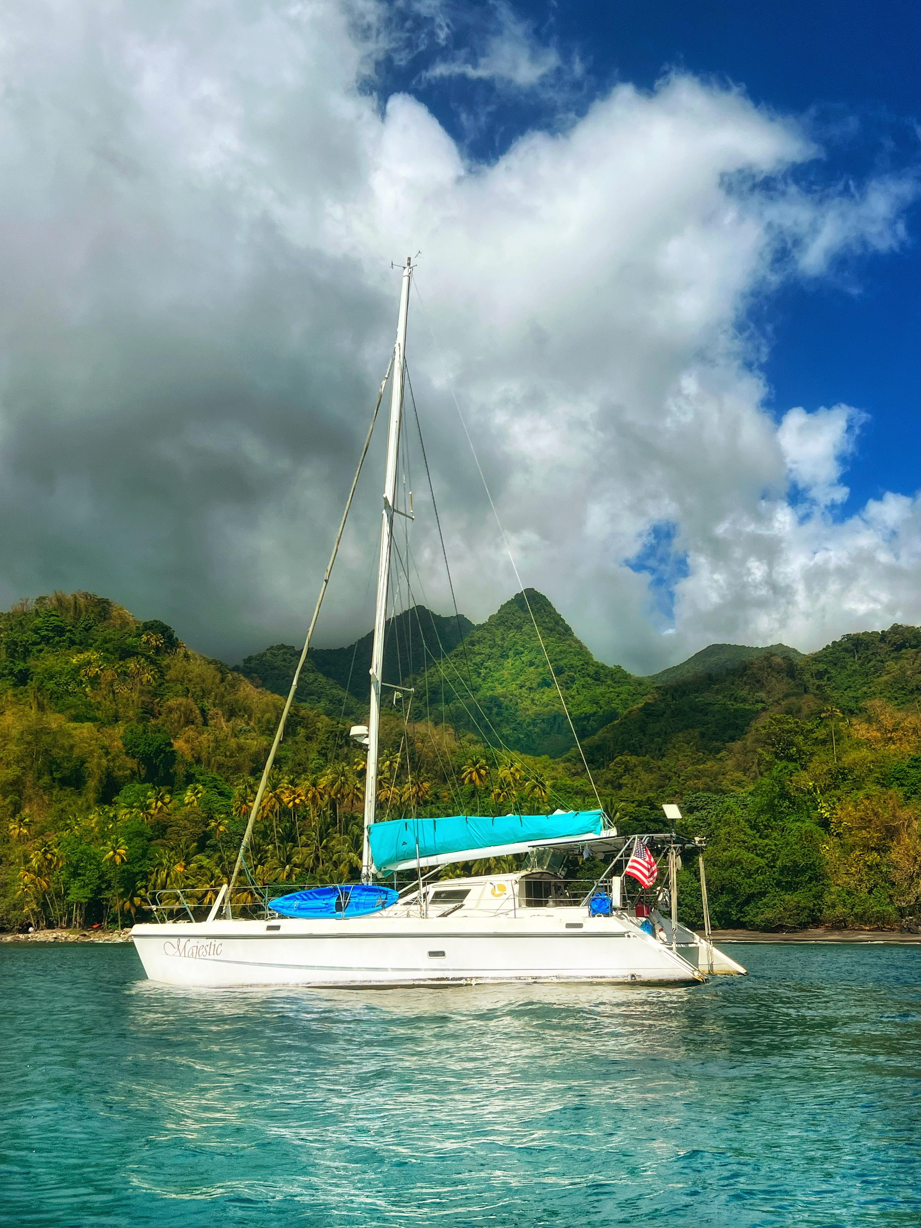 Sailboat St Francis 44 MKII, 1999, anchored near lush green mountains under cloudy sky.