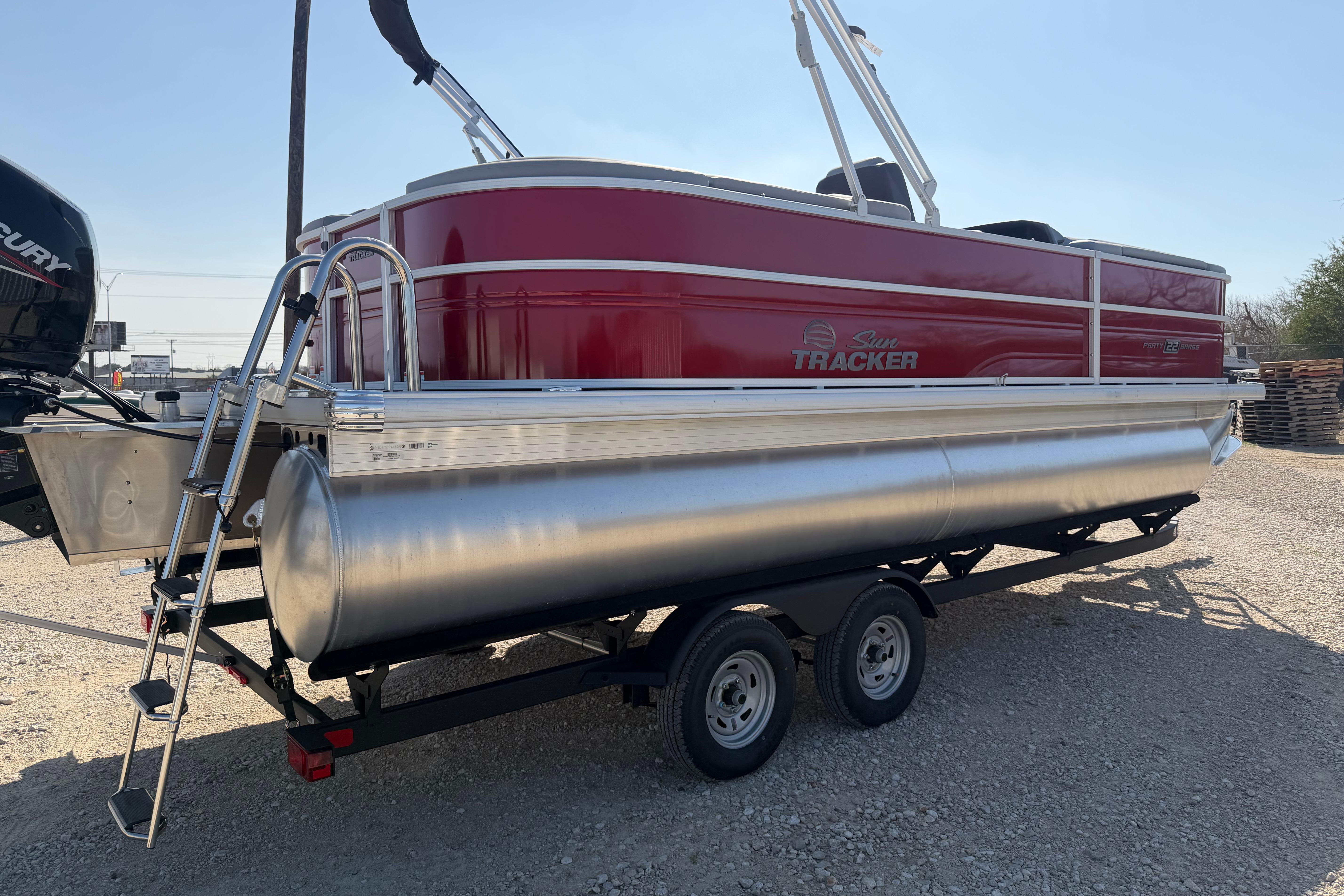 2026 Sun Tracker Party Barge 22 DLX pontoon boat on trailer, side view.