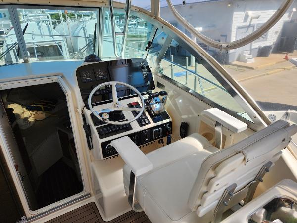2005 Pursuit 3070 Offshore Center Console helm with steering wheel and navigation controls.