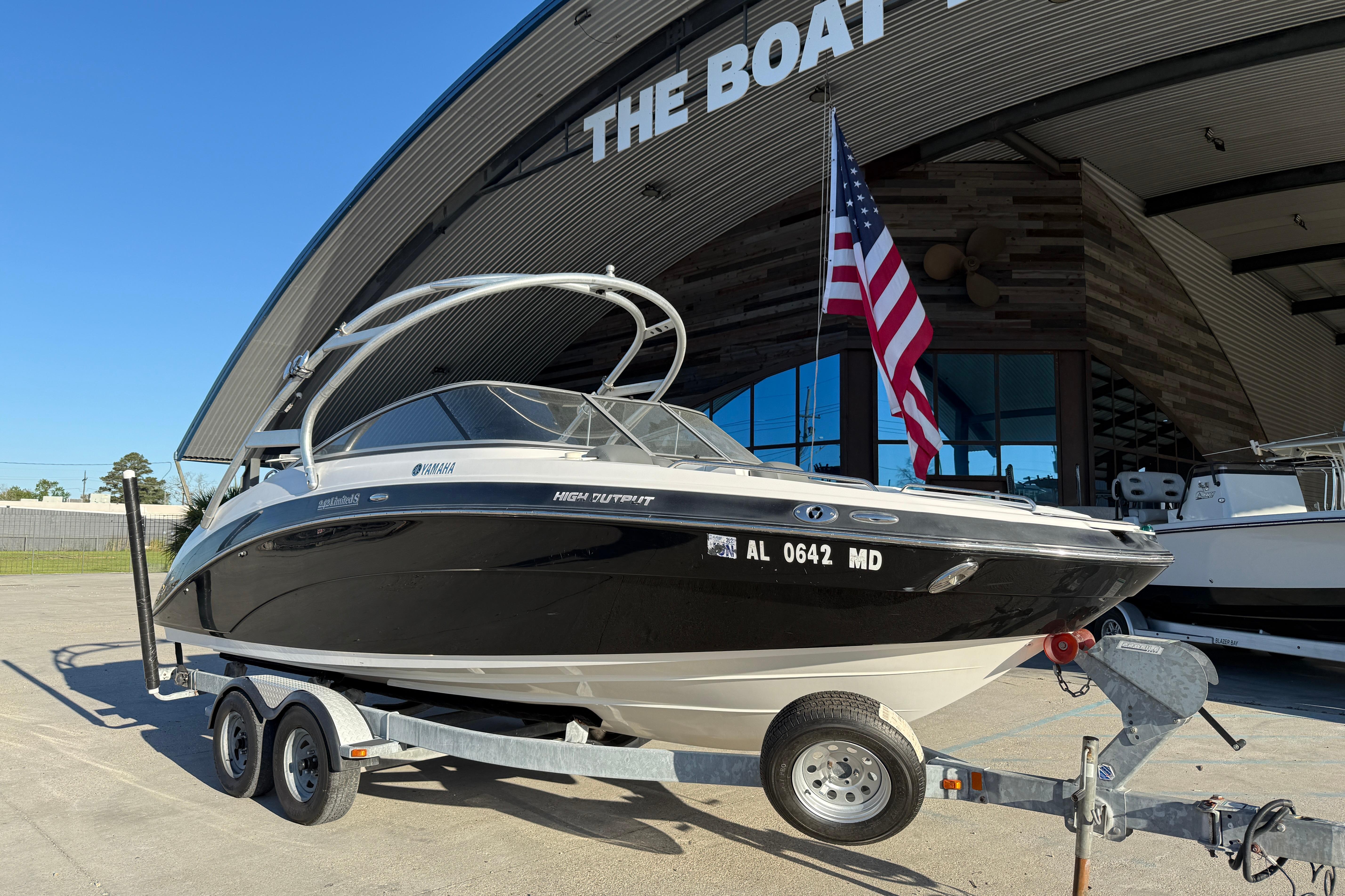 2011 Yamaha Boats 242 Limited S on trailer outside a boat dealership.