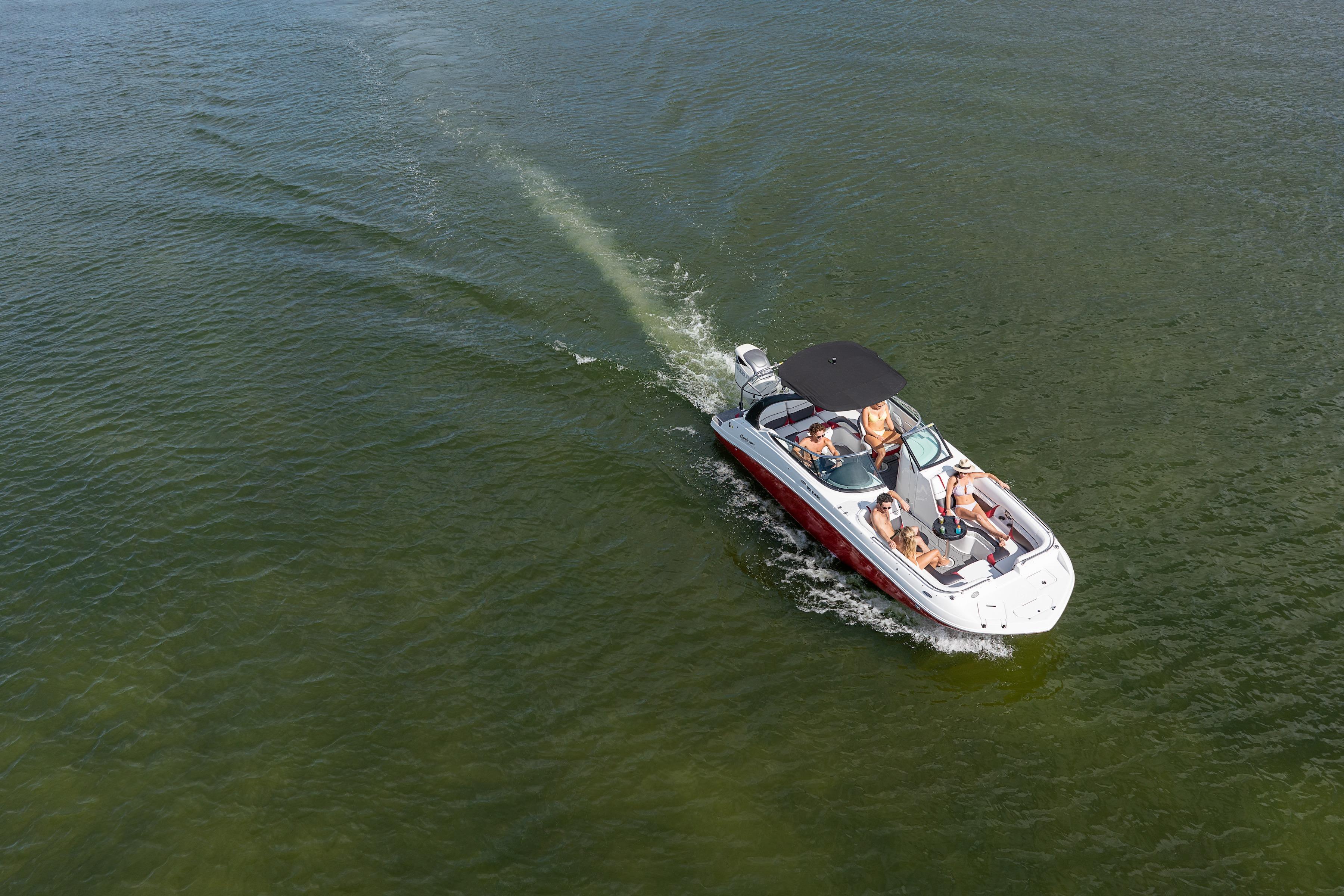 2026 Hurricane SunDeck 2486 OB boat cruising on open water with passengers.