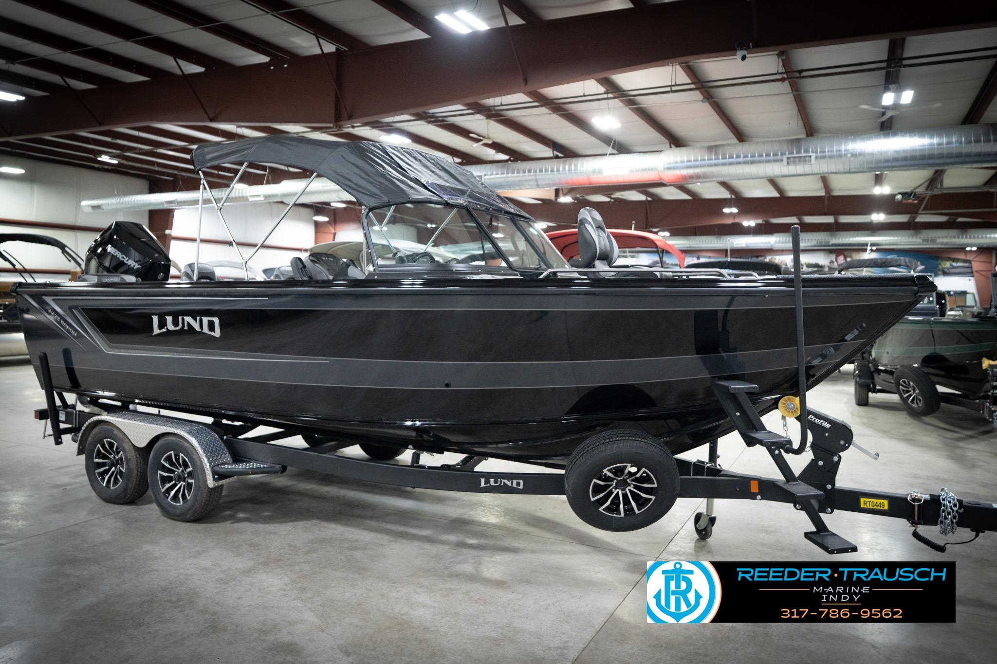 2026 Lund 2275 Baron boat on trailer in indoor showroom.