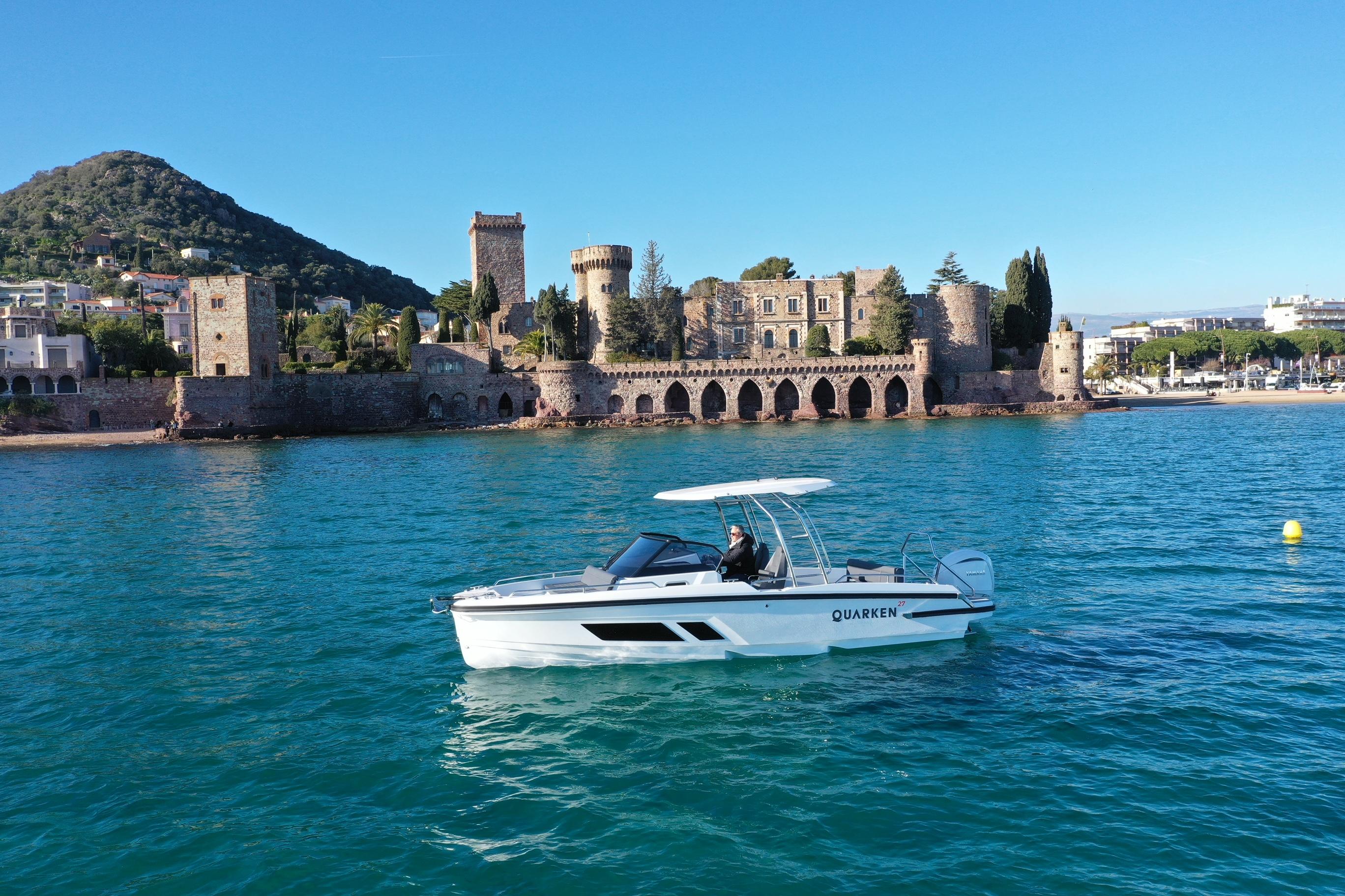 2025 Quarken 27 T-Top boat cruising near historic coastal architecture.