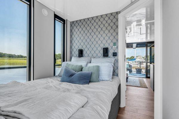 Modern bedroom in La Mare Modern 11 houseboat, 2024 model, with scenic water views.