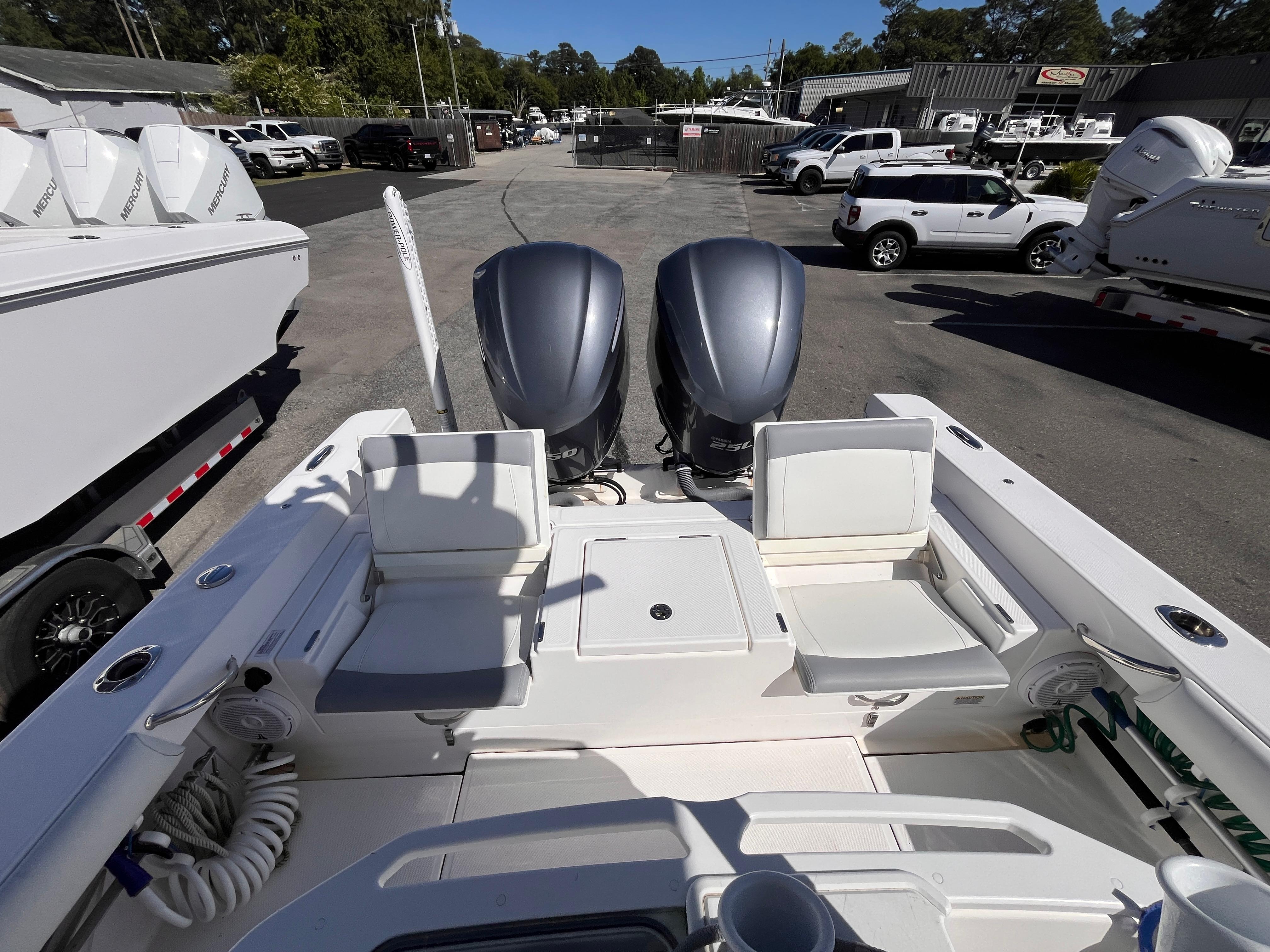 2017 Everglades 273 Center Console boat with dual engines, parked in a marina lot.