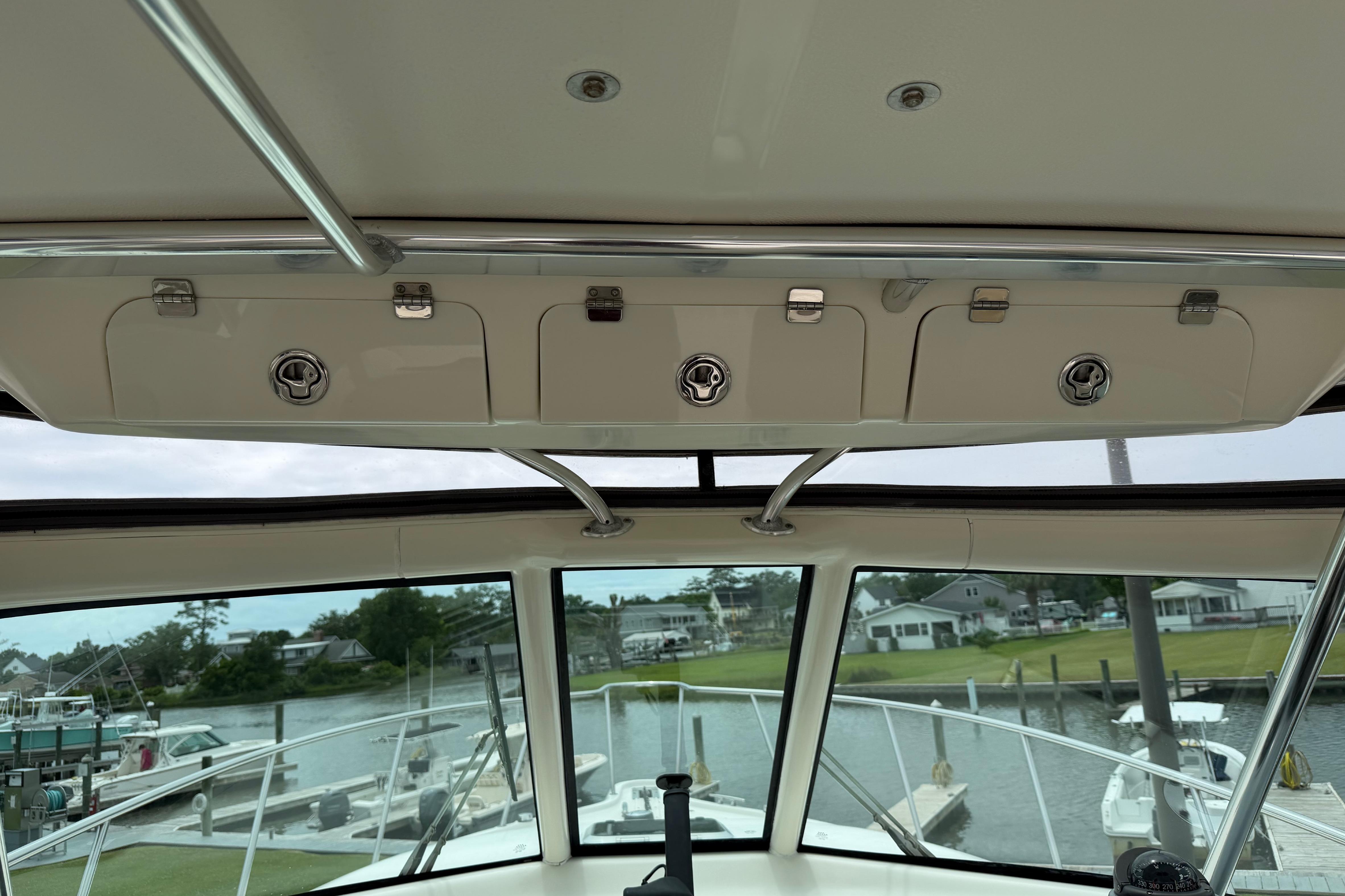 2008 Pursuit OS 335 Offshore boat interior with overhead storage and marina view.