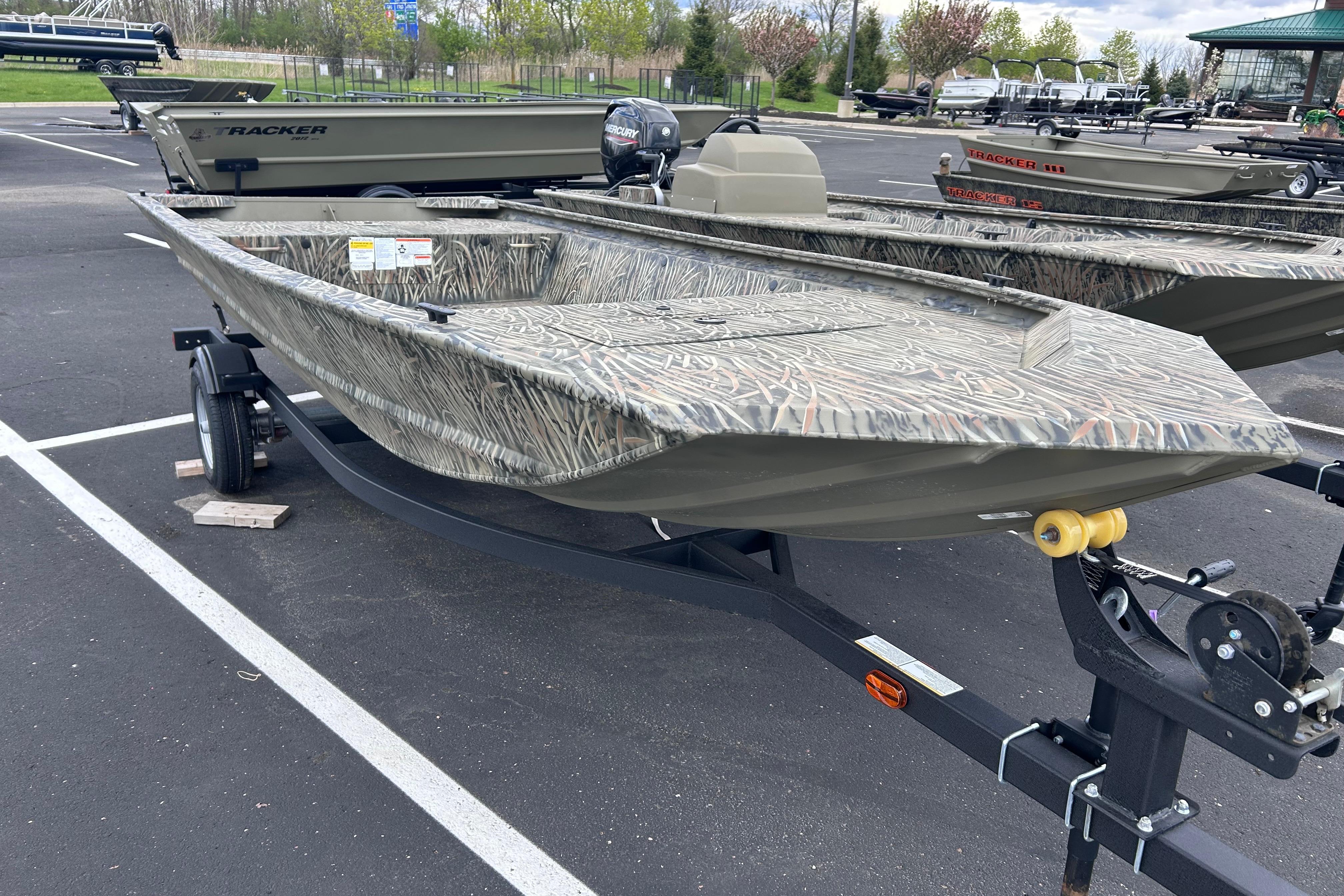 2026 Tracker Grizzly 1648 Utility boat on trailer in parking lot.