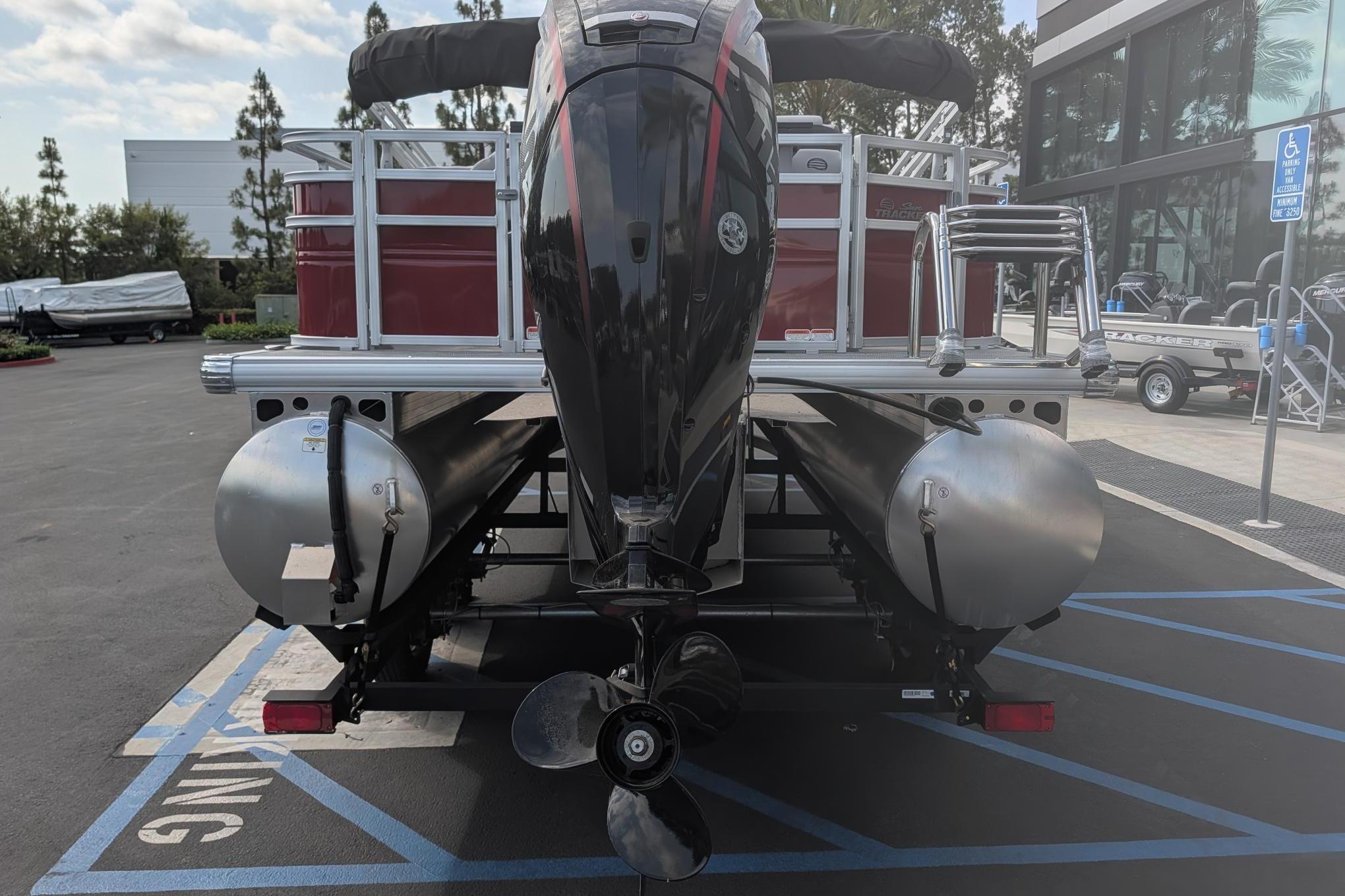 2026 Sun Tracker SportFish 20 DLX pontoon boat rear view in parking lot.