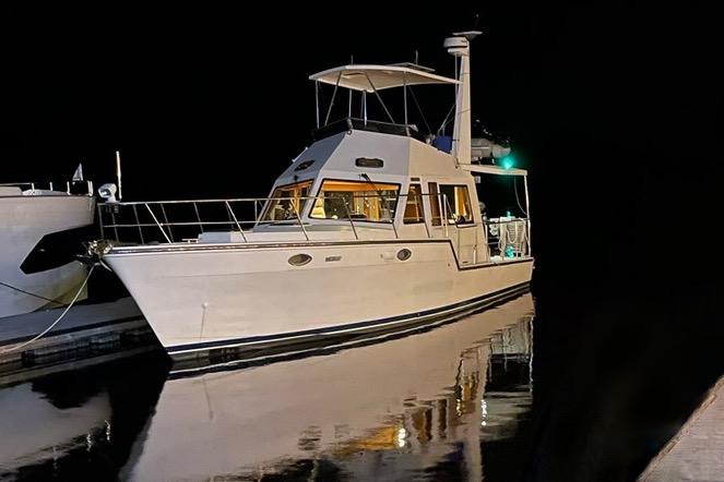 2007 Island Pilot 395 yacht docked at night, reflecting on calm water.