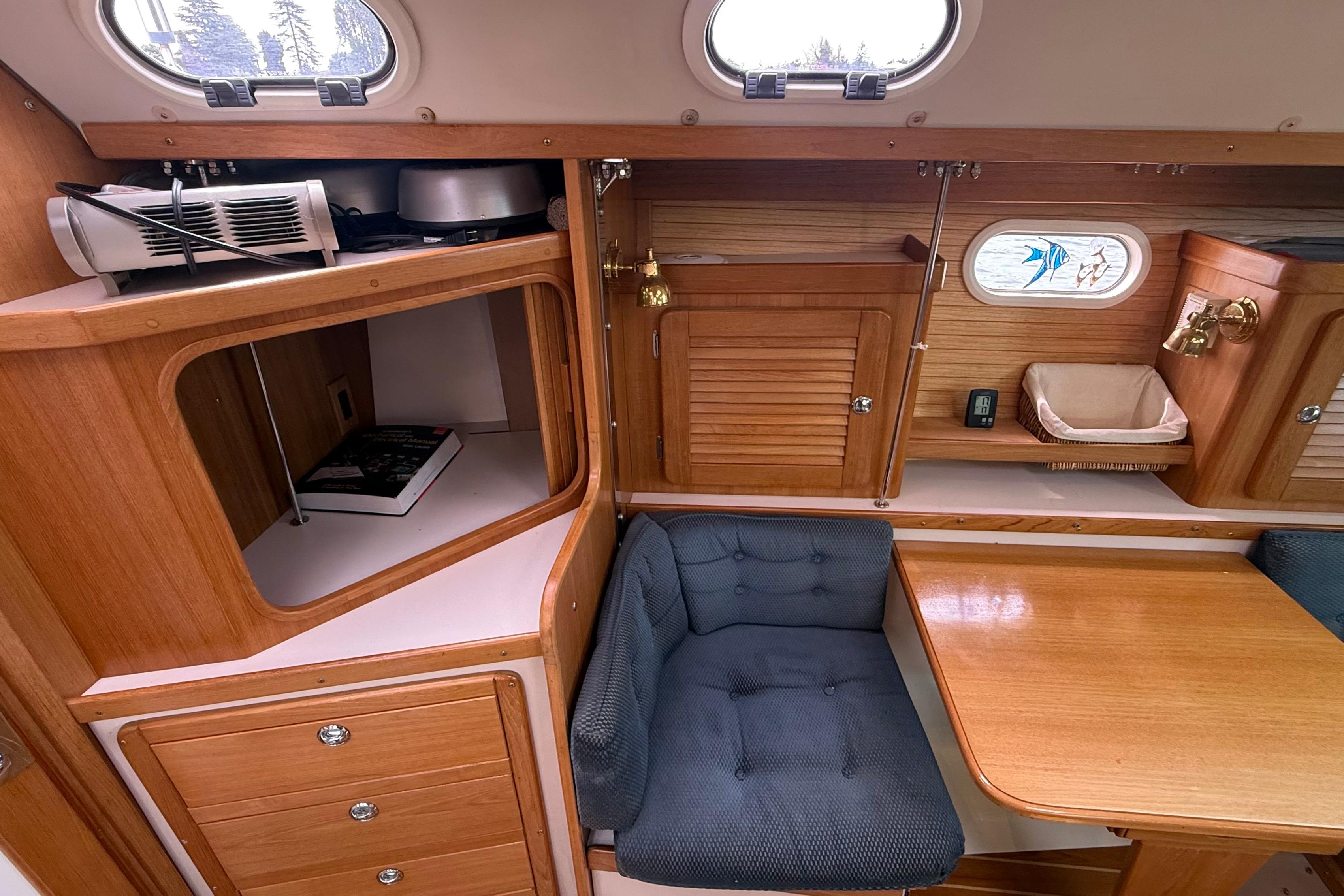Interior of 2005 Catalina 36 MkII sailboat with wooden cabinetry and cozy seating area.