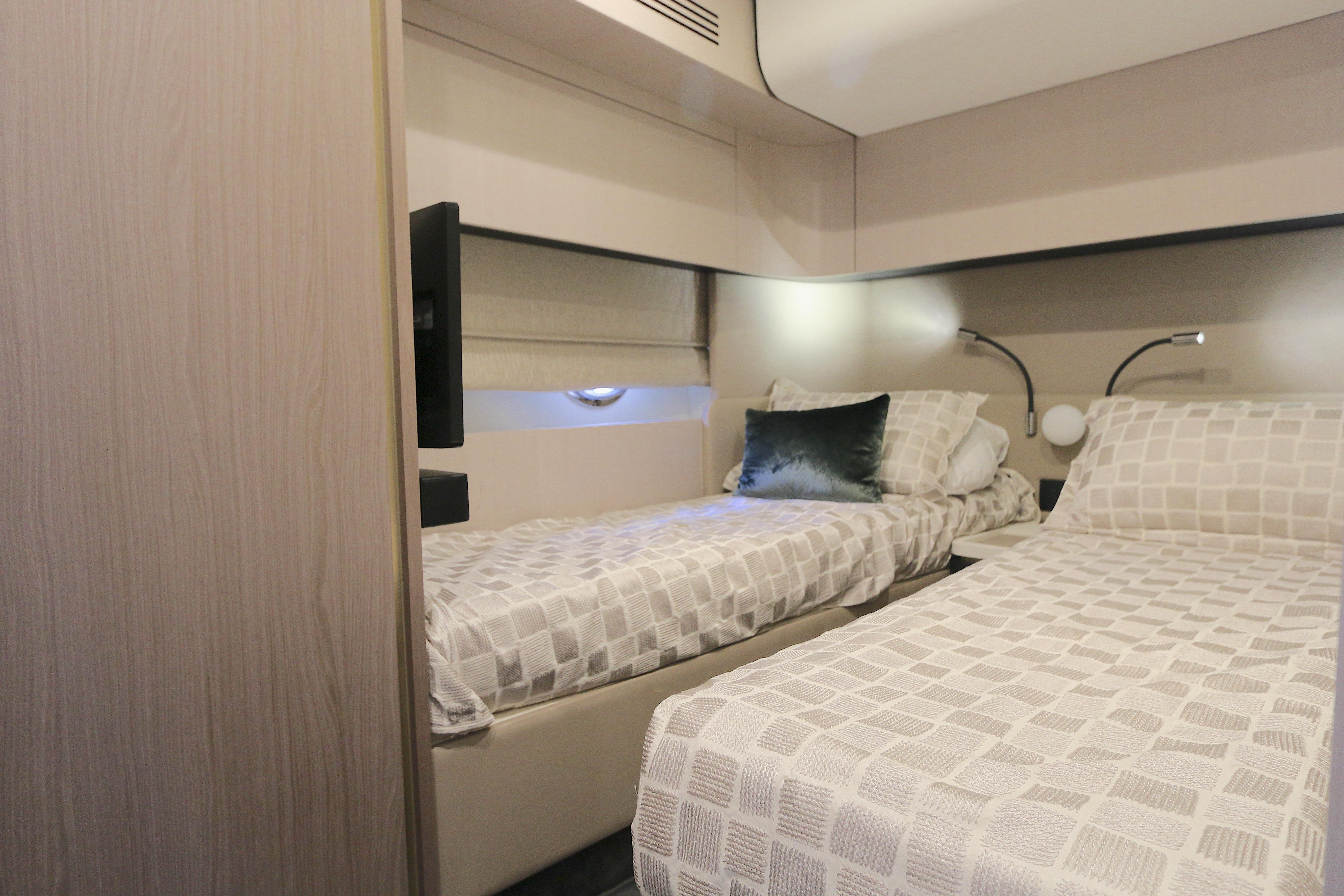 Luxurious cabin interior of 2020 Azimut 55 yacht with twin beds and modern decor.