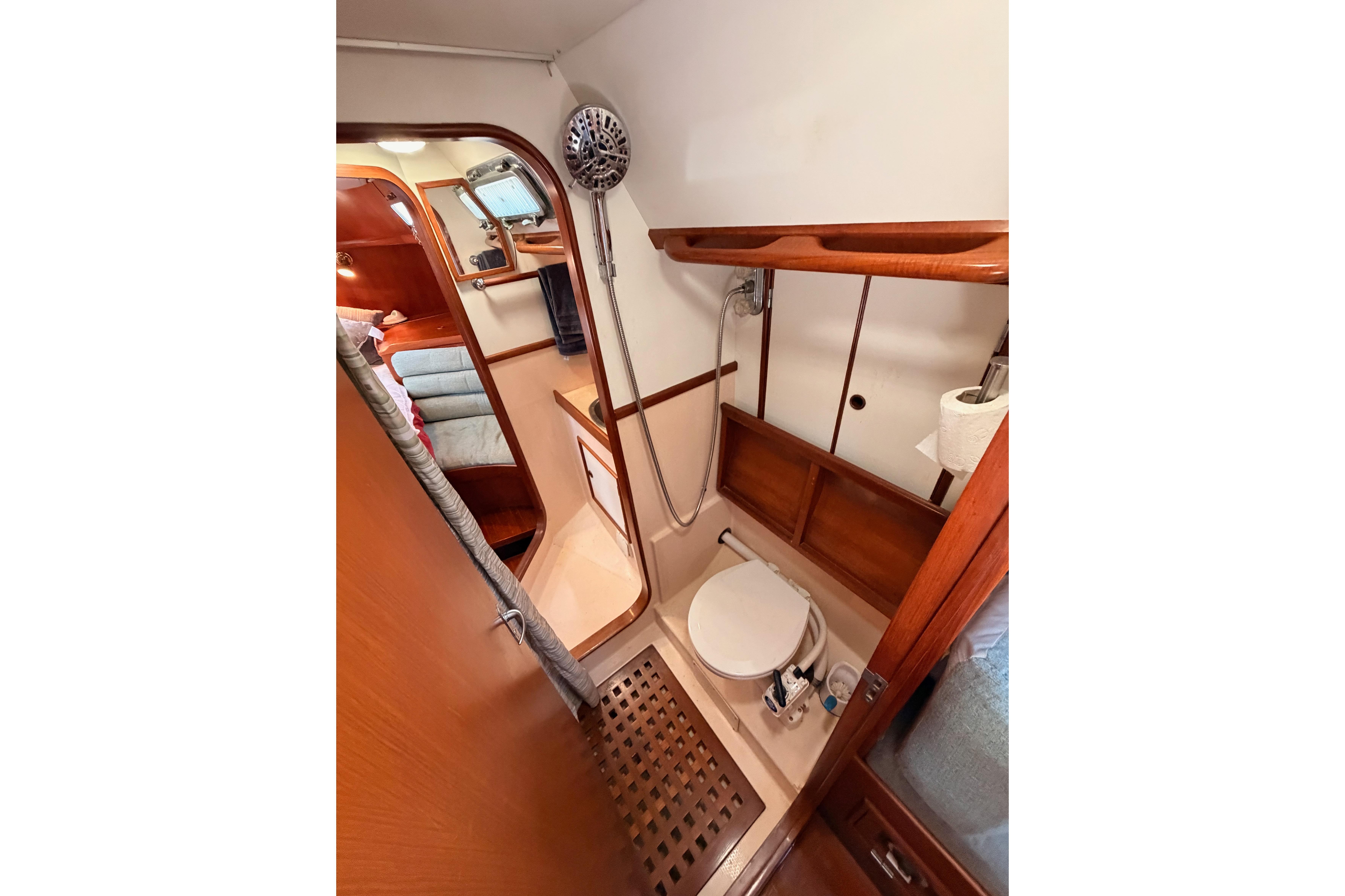 Bathroom interior of a 1991 Hylas 51 yacht, featuring wooden accents and compact design.