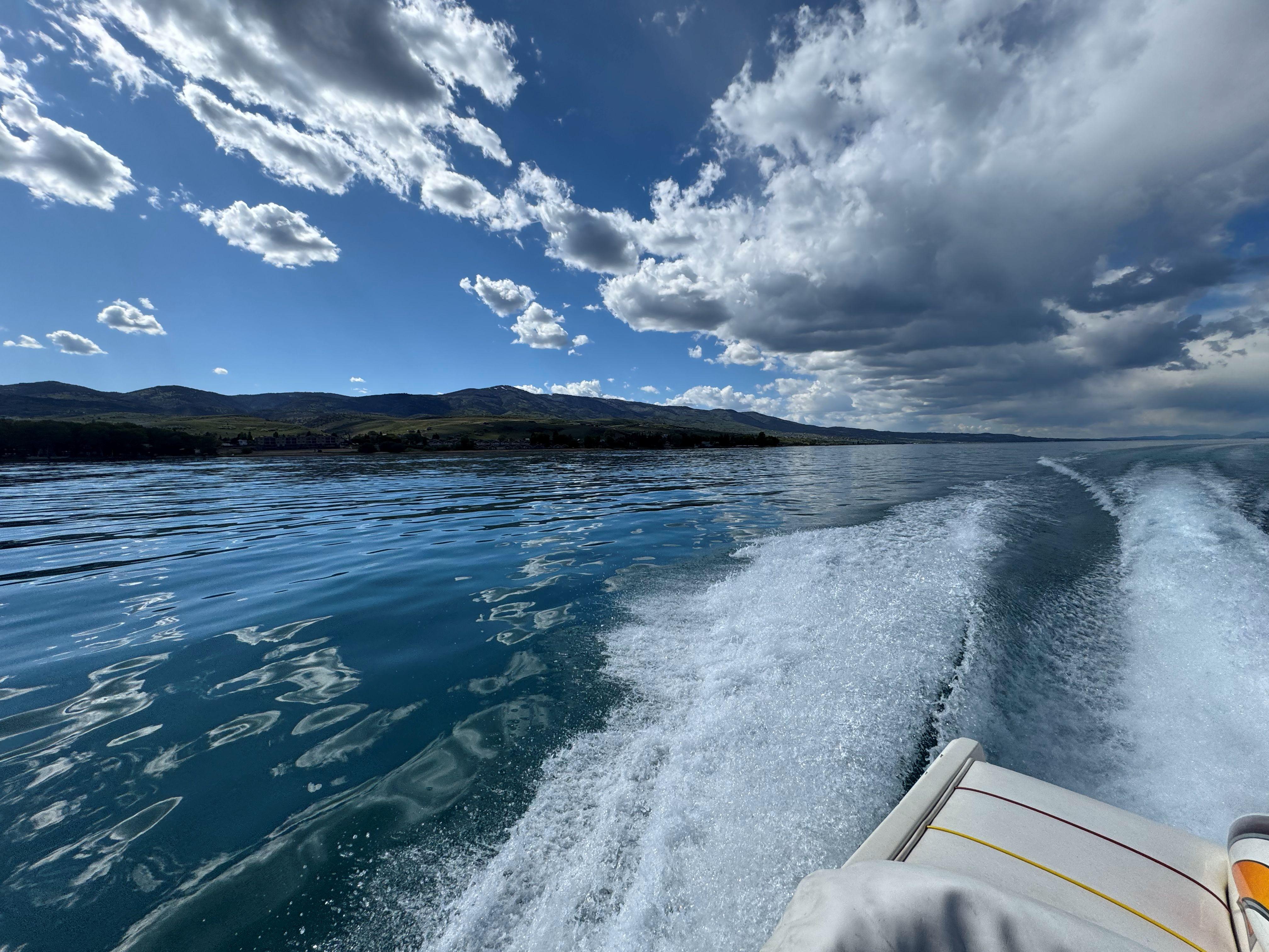 Boat cruising on a lake under cloudy sky, Advantage Victory 2002 model.