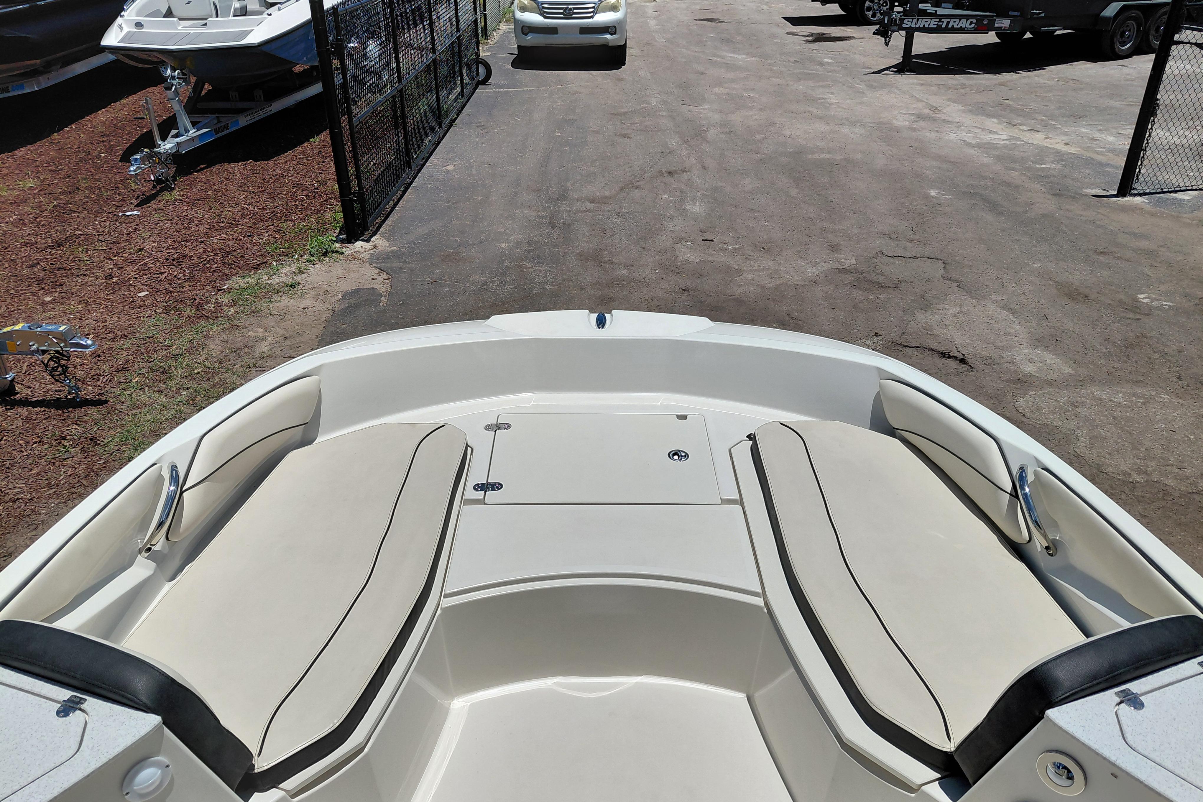 2023 Stingray 206 CC boat interior with beige seating, parked outdoors.