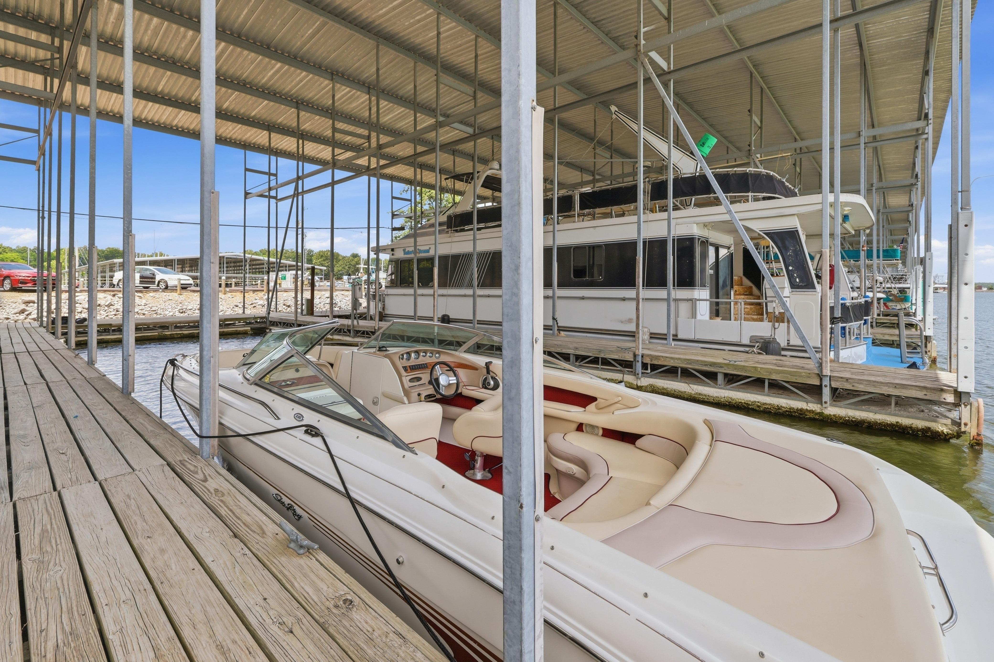 1997 Sea Ray 230 Signature boat docked in a marina under a covered structure.