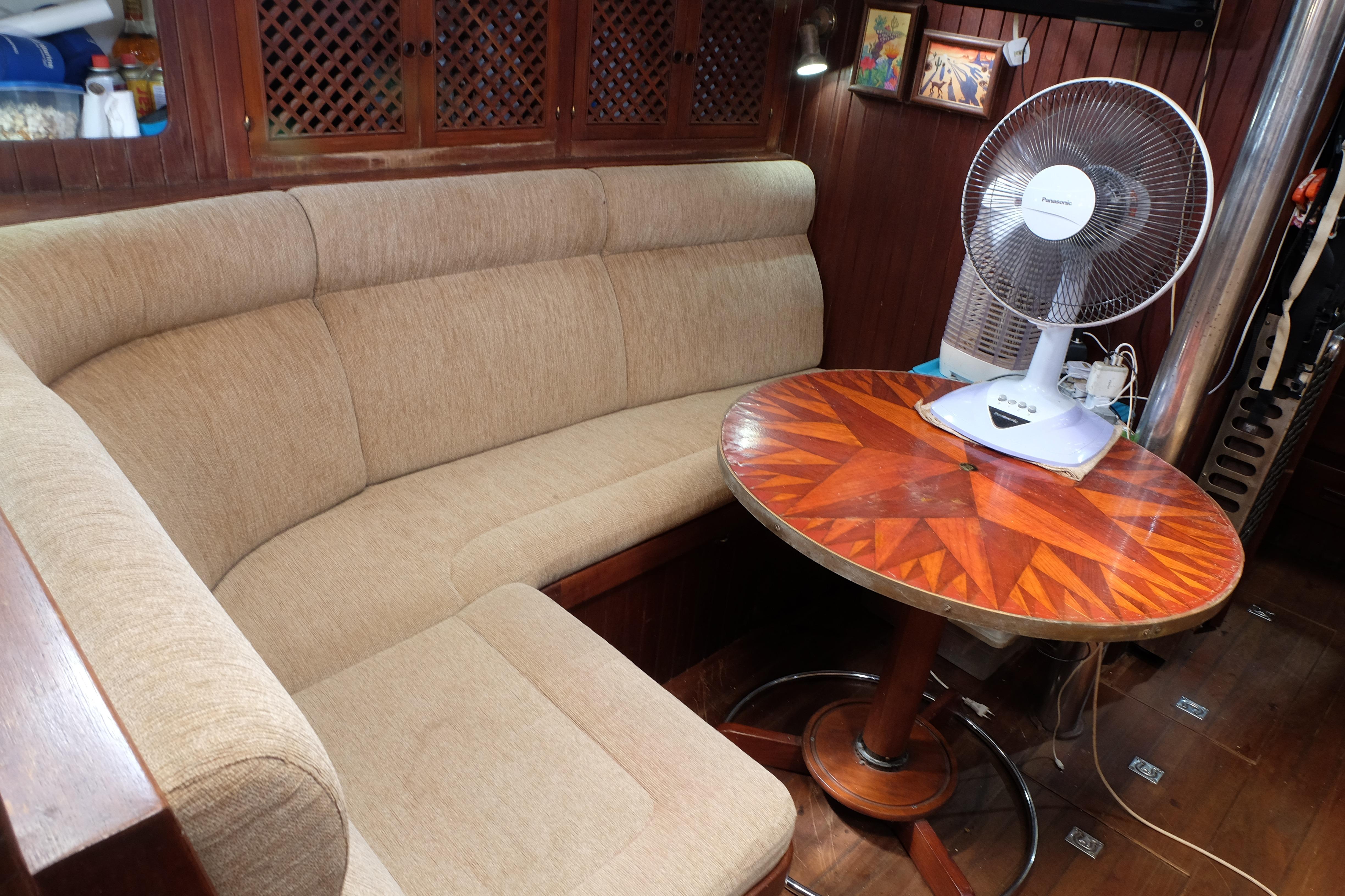 Cozy 1979 Westwind 35 yacht interior with cushioned seating and decorative wooden table.