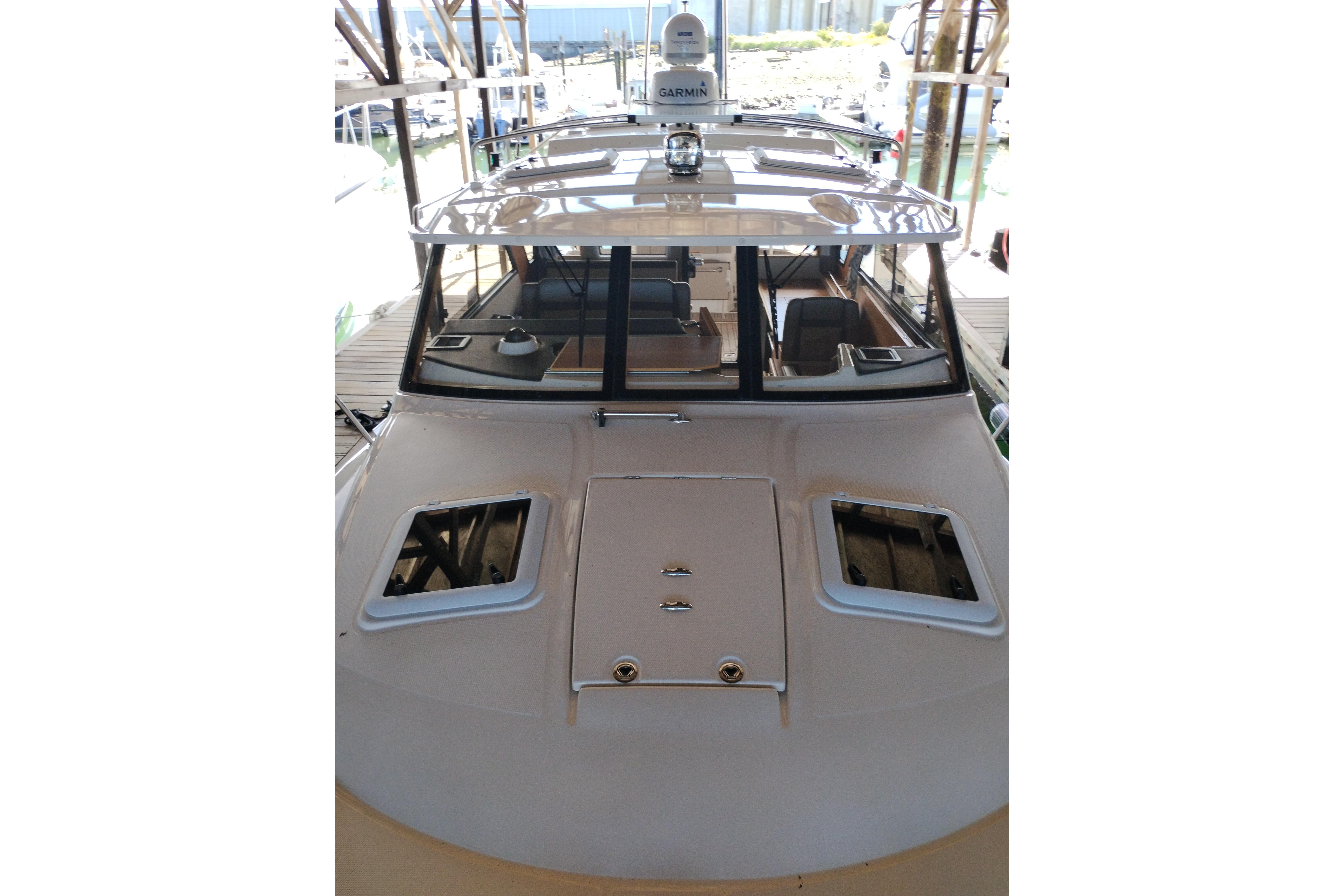 2022 Cutwater C-32 Coupe boat docked, showcasing sleek design and spacious deck.
