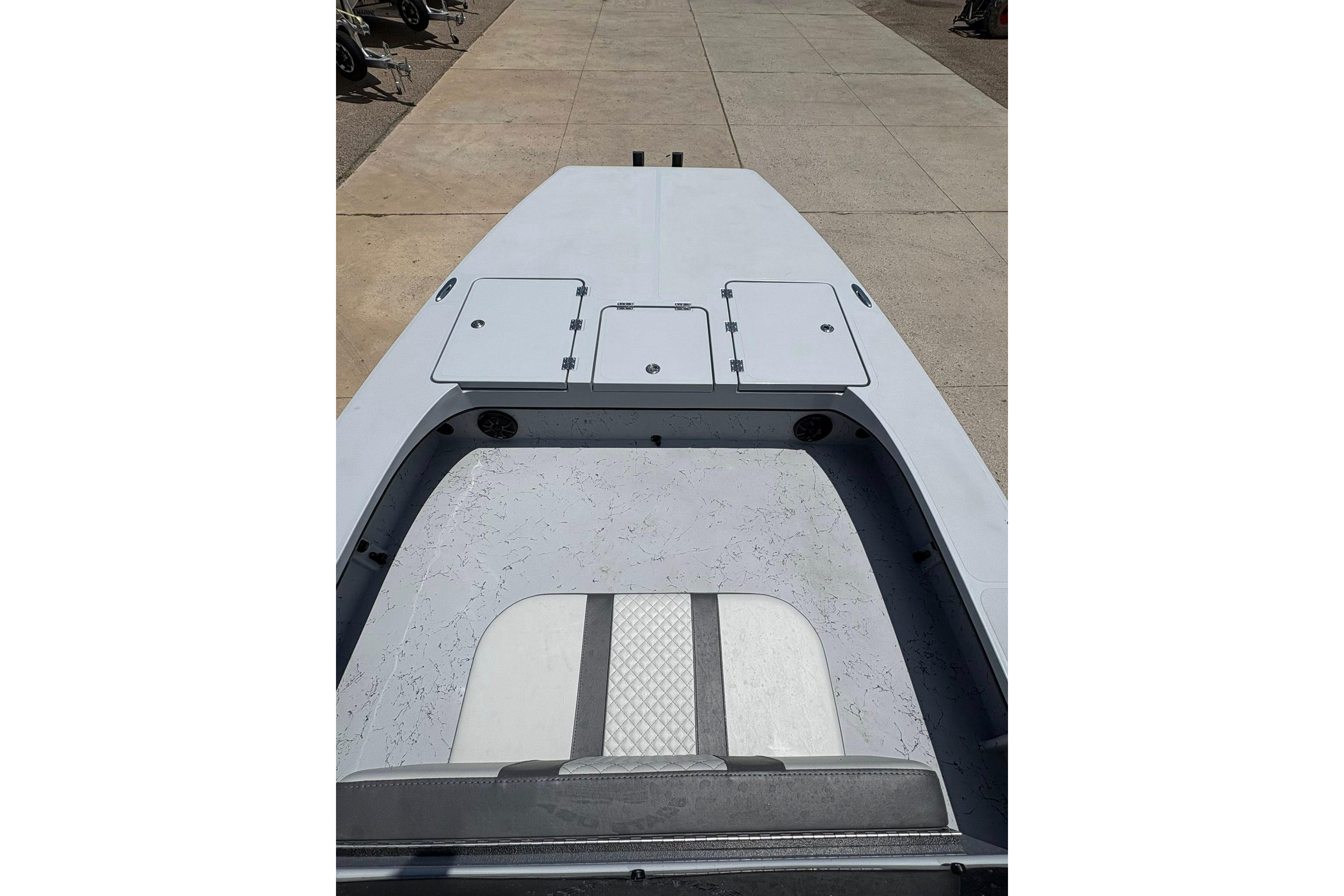 2026 Freedom Boats 23' Warrior deck view, showcasing storage compartments and seating area.