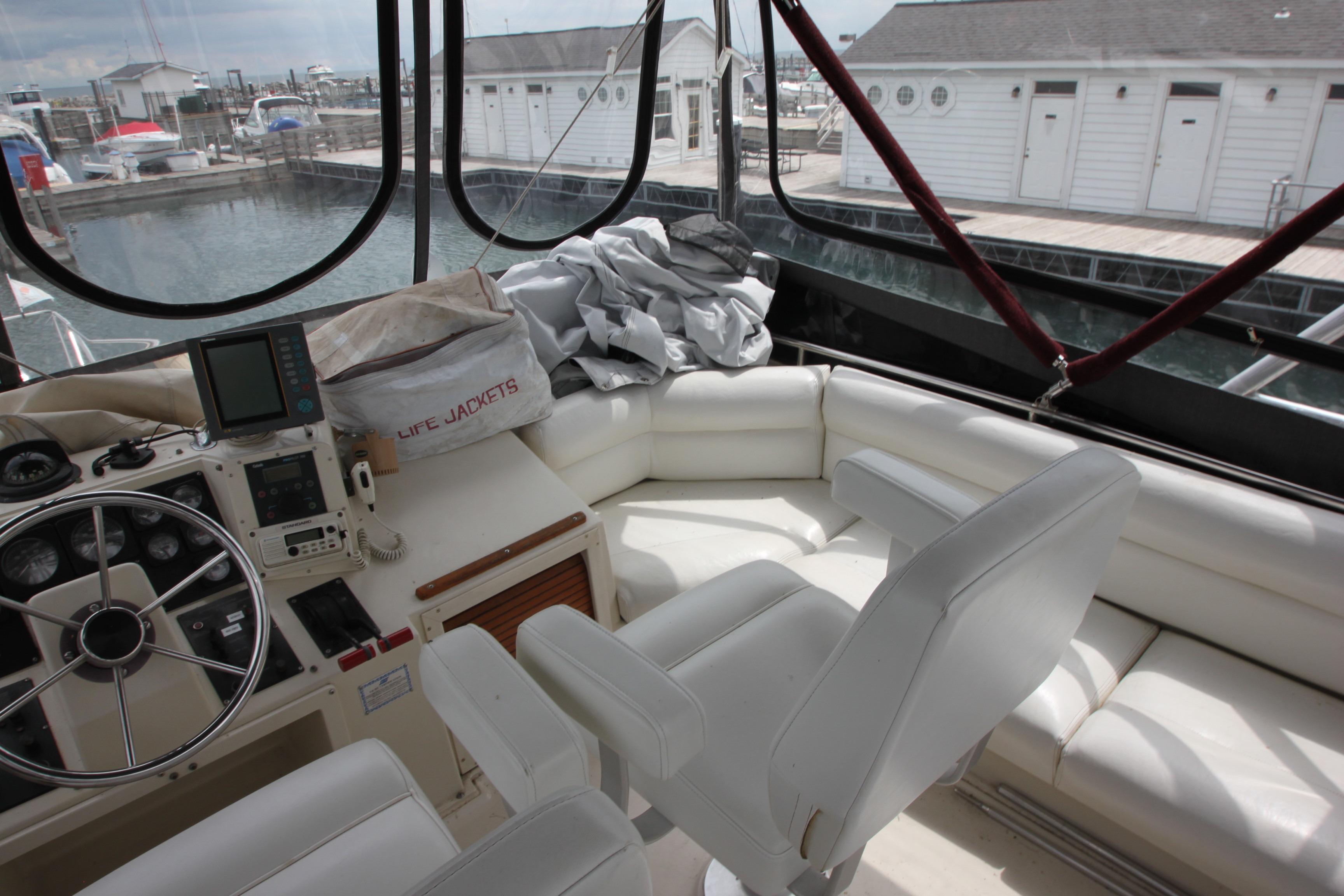 1990 Silverton 34 Convertible yacht interior with white seating and navigation equipment.