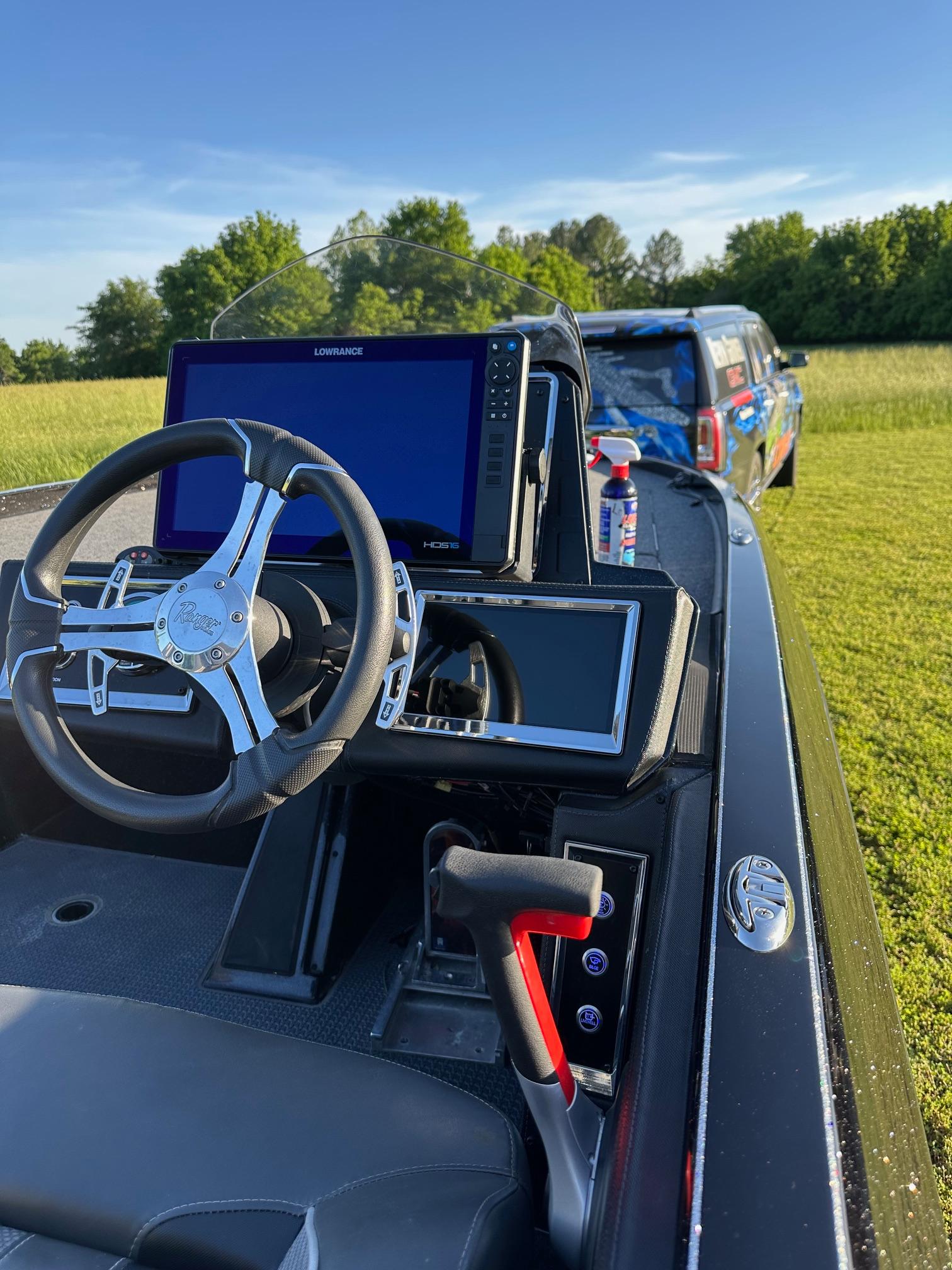 2023 Ranger Z521R boat dashboard with steering wheel and navigation screens in a grassy field.