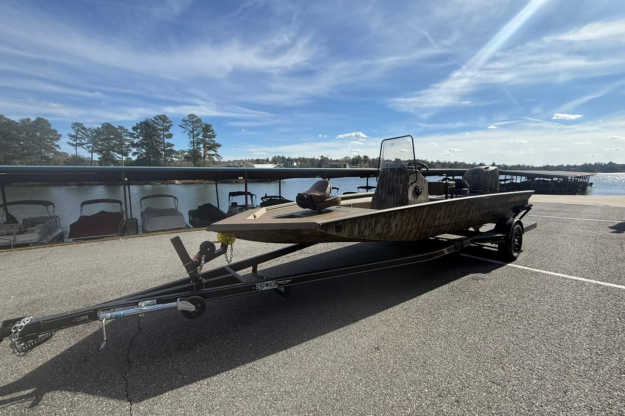 2026 Excel 206 Stalker CC boat on trailer by a lake under a clear sky.