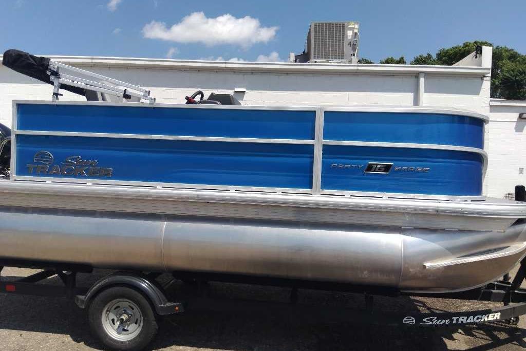 2026 Sun Tracker Party Barge 16 DLX pontoon boat with blue exterior on trailer.
