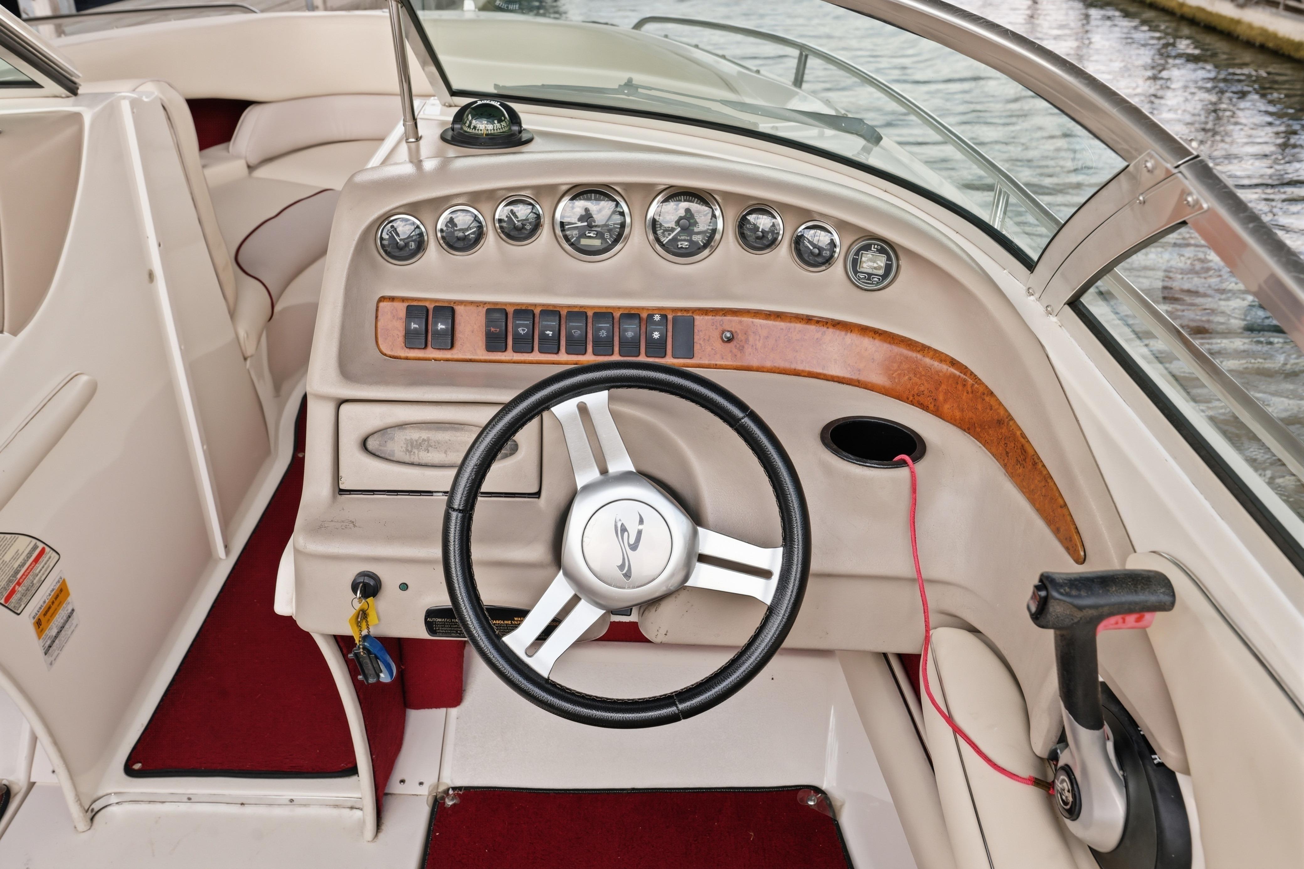 1997 Sea Ray 230 Signature boat dashboard with steering wheel and instrument panel.