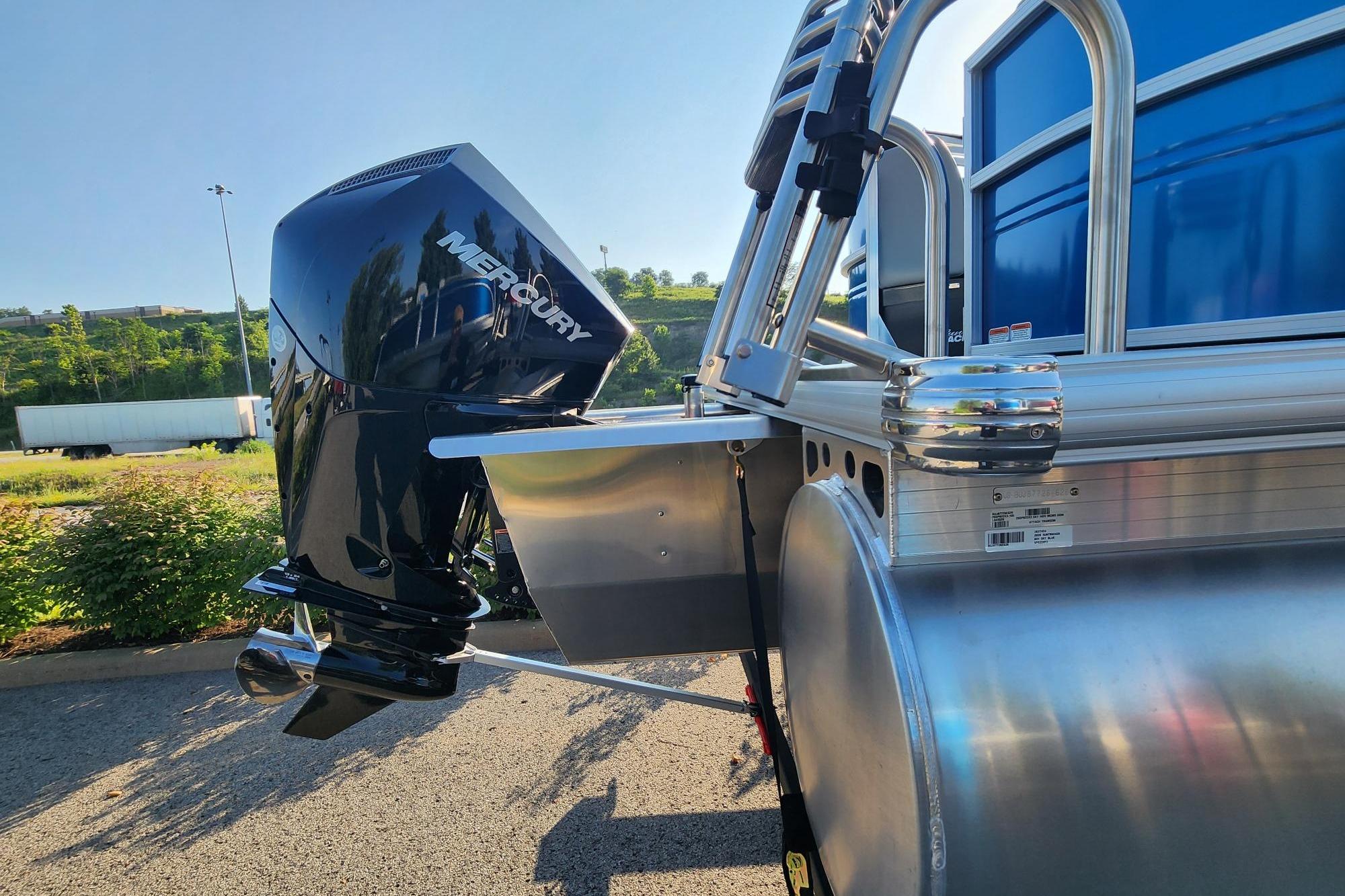2026 Sun Tracker Party Barge 22 XP3 with Mercury outboard motor, parked outdoors.