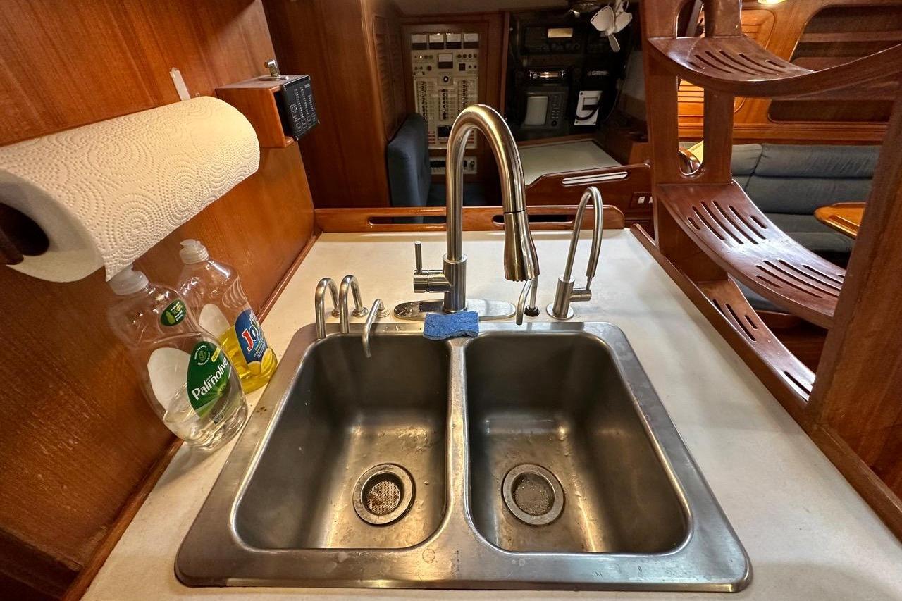 Galley sink area on a 1989 Hylas 44 yacht with dual faucets and dish soap.
