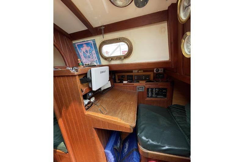 1980 Ta Shing Baba 30 sailboat interior with navigation station and wooden finish.