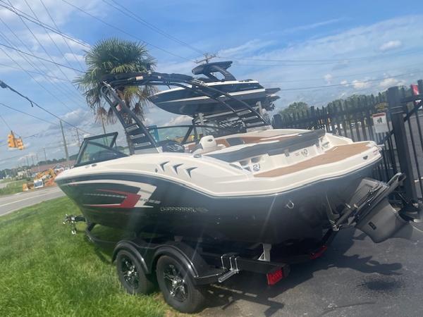2025 Chaparral 21 SSi boat on trailer, parked near road with palm tree.