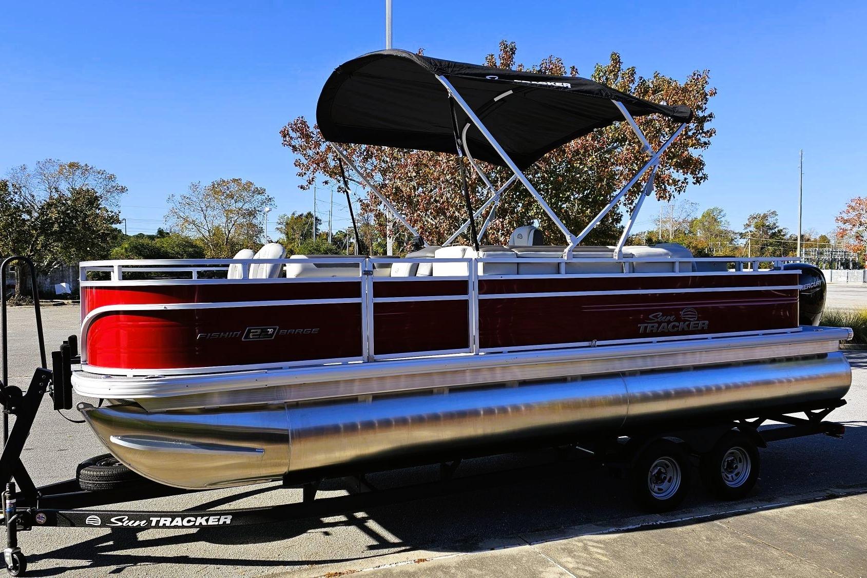 2026 Sun Tracker Fishin' Barge 22 DLX pontoon boat with canopy on trailer.