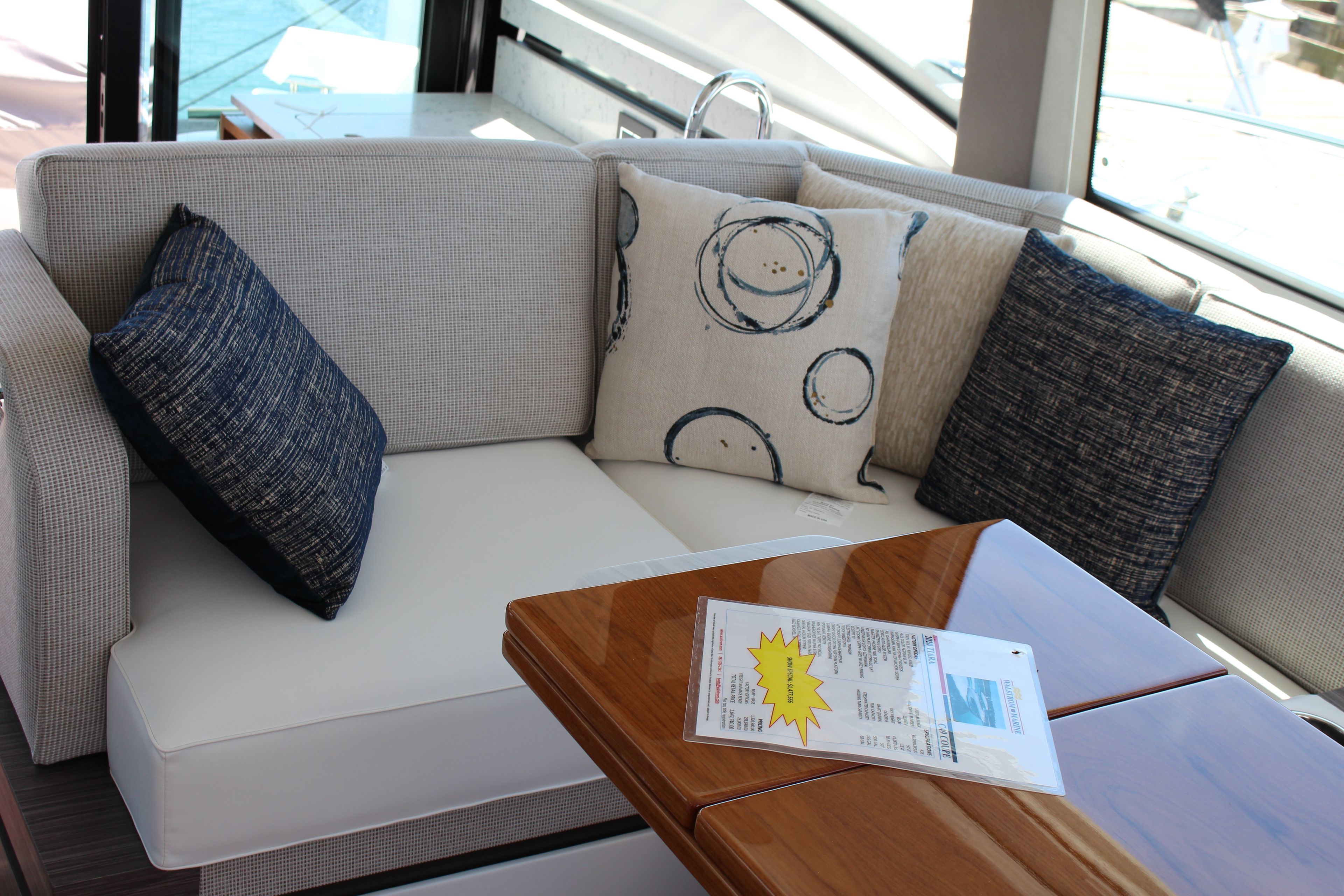 Luxurious interior seating on 2020 Tiara Yachts C49 Coupe with stylish cushions and wooden table.
