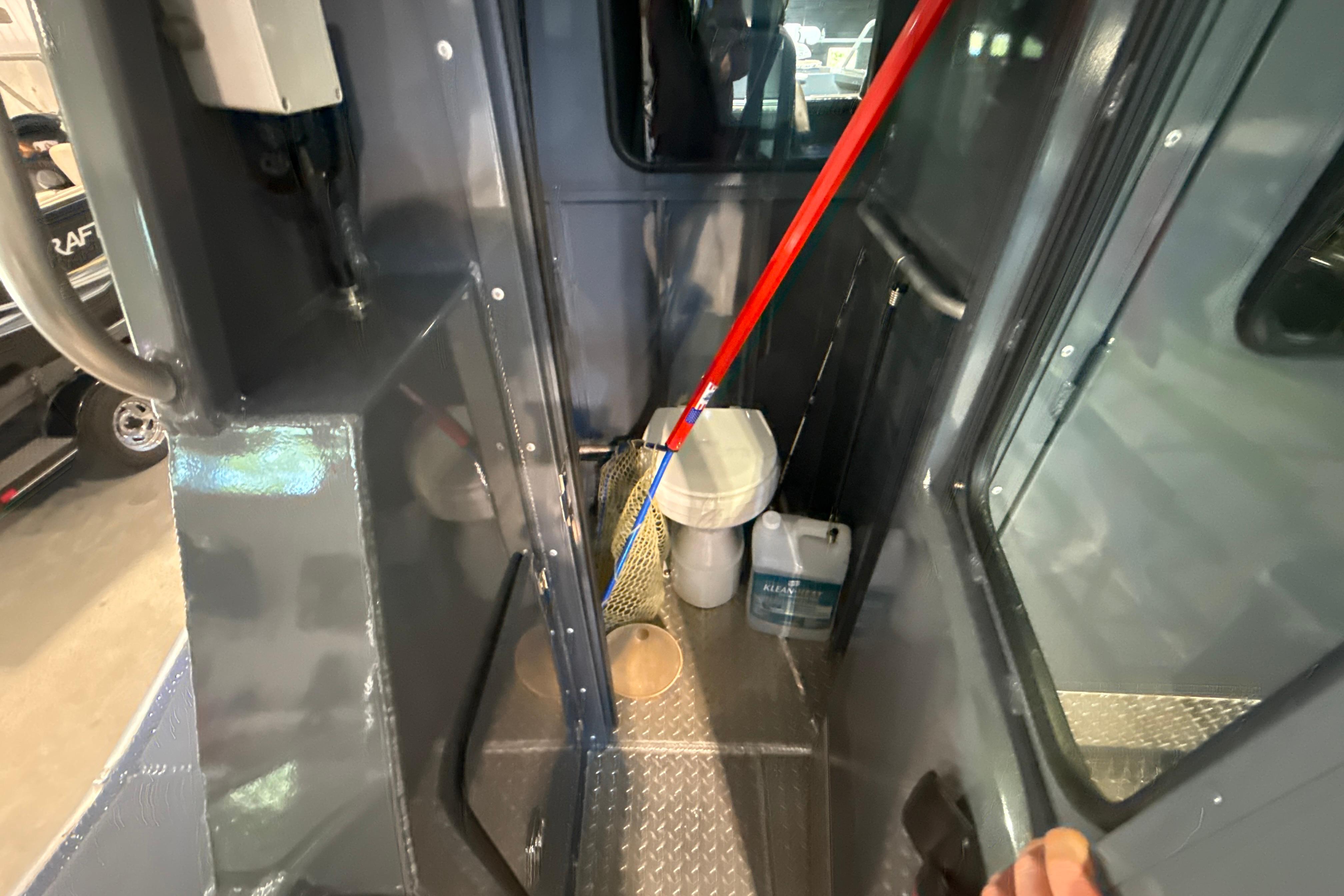 Interior of 2022 Hewescraft 270 Alaskan Hardtop, featuring storage area and cleaning supplies.