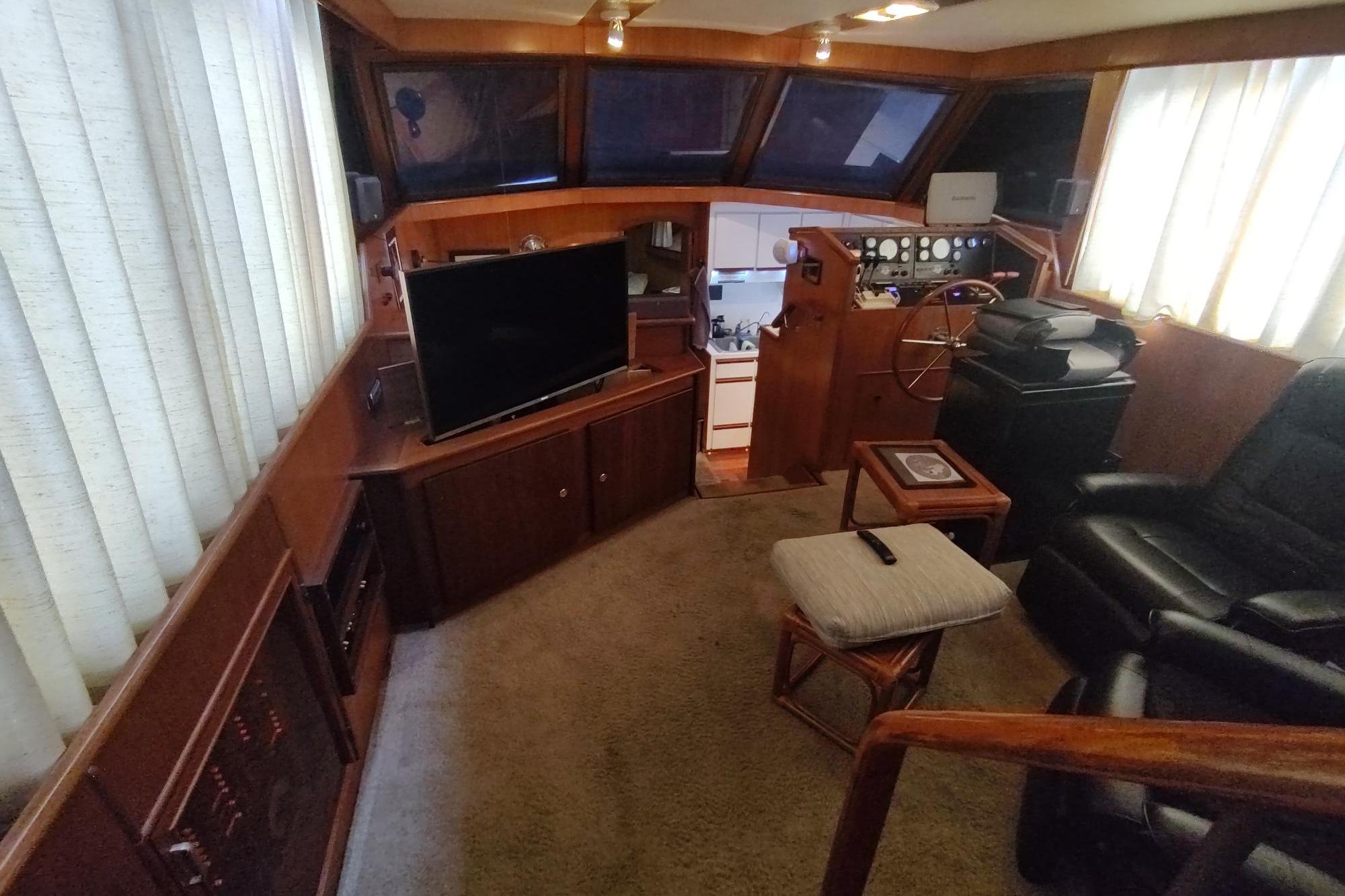 Luxurious interior of a 1989 Hyatt Double Cabin Motoryacht with helm, seating, and TV.