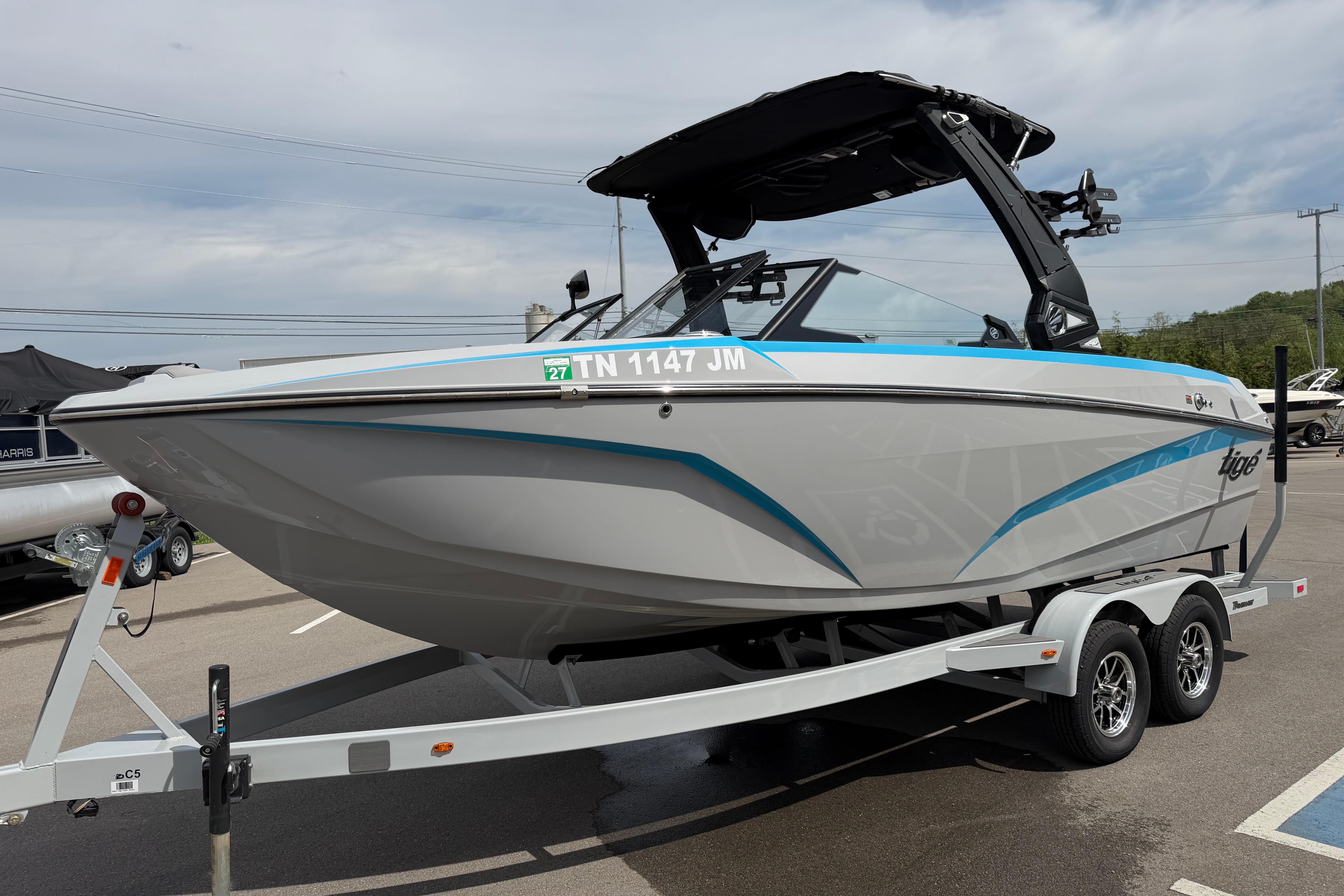 2024 Tigé Z1 boat on trailer, sleek design with blue accents, parked outdoors.